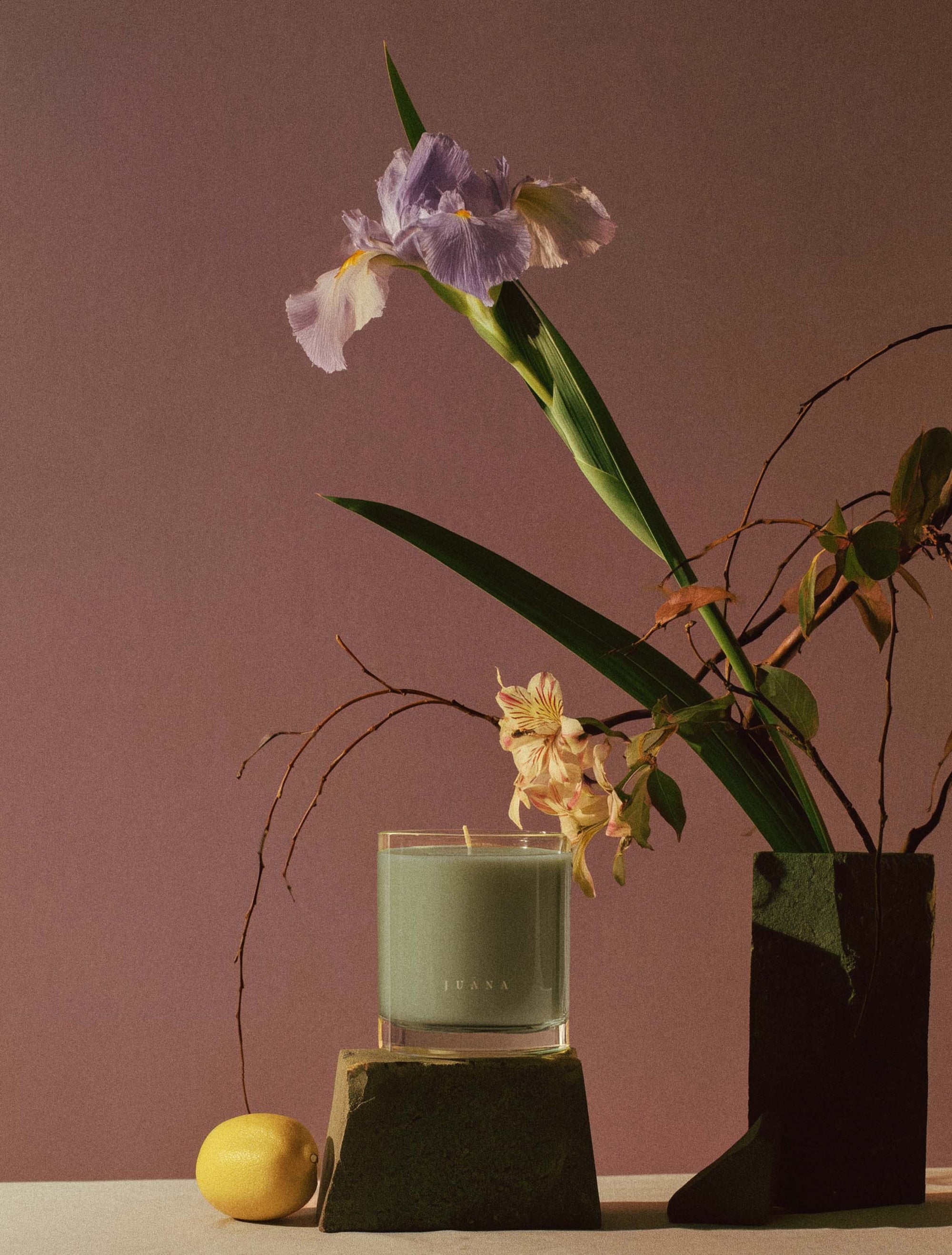 Juana Sage Indica Calm apothecary medium candles beside a flower in vase, vegan, eco-friendly.