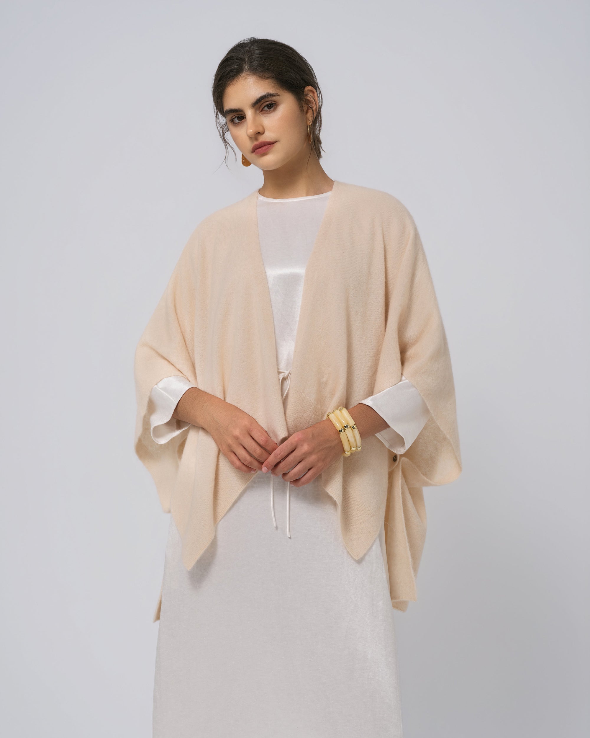 Styled look: almond milk cashmere–wool–hemp cape layered over silk dress; elevated everyday wear.