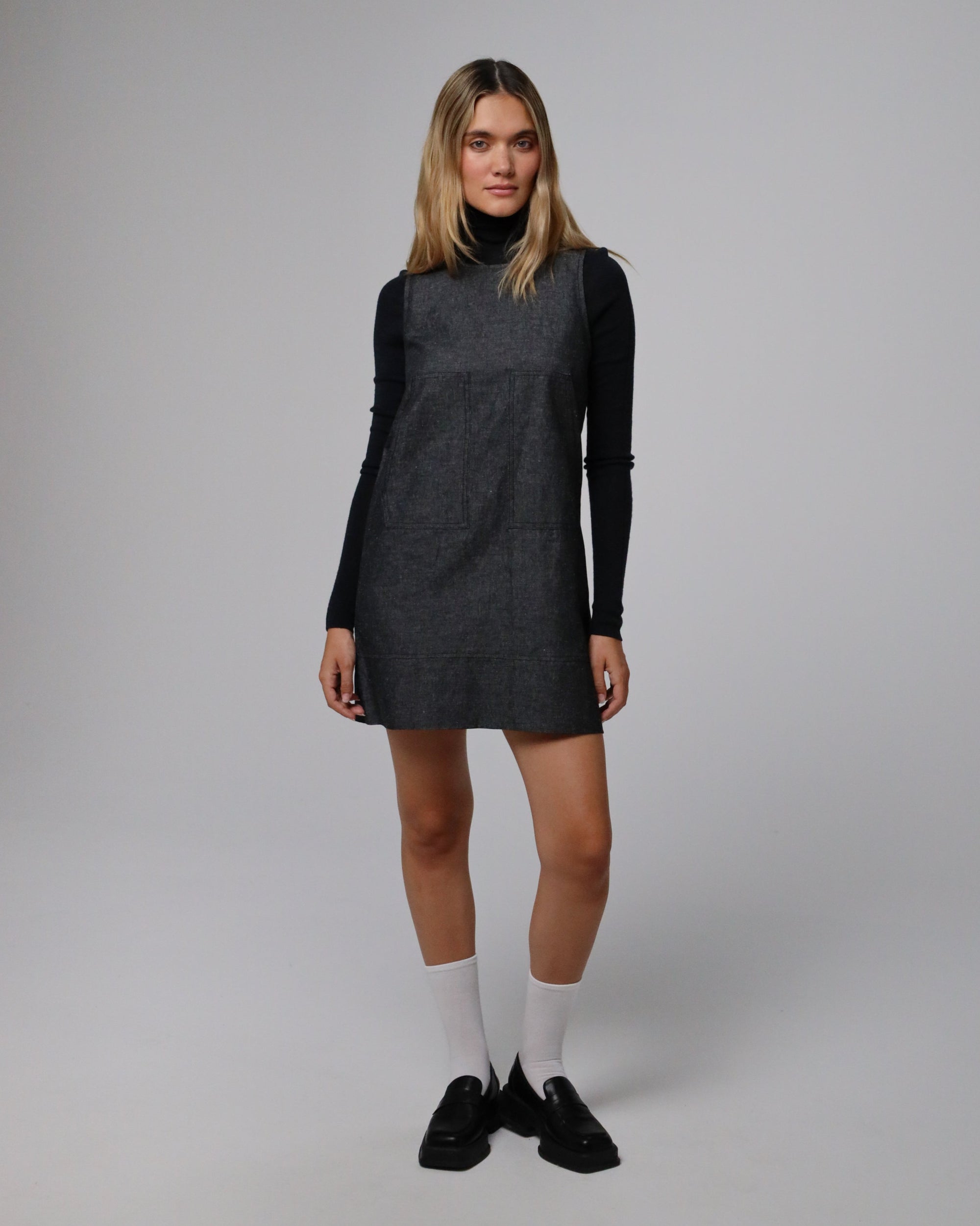Model wearing Juana Denim Atelier Shift Dress in black denim (hemp–organic cotton), showcasing a clean, minimalist silhouette.