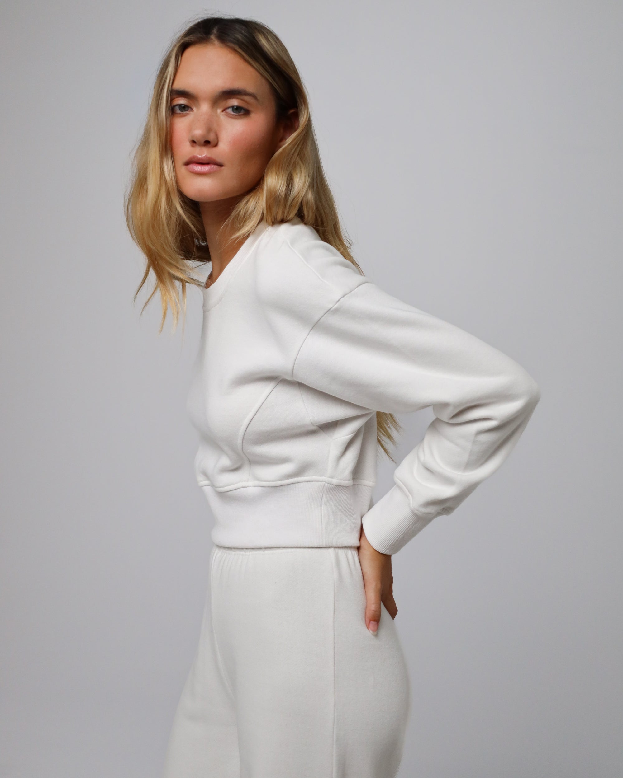 Woman wearing Fleece Cropped Sweater in white hemp–organic cotton blend, styled for sustainable everyday wear.