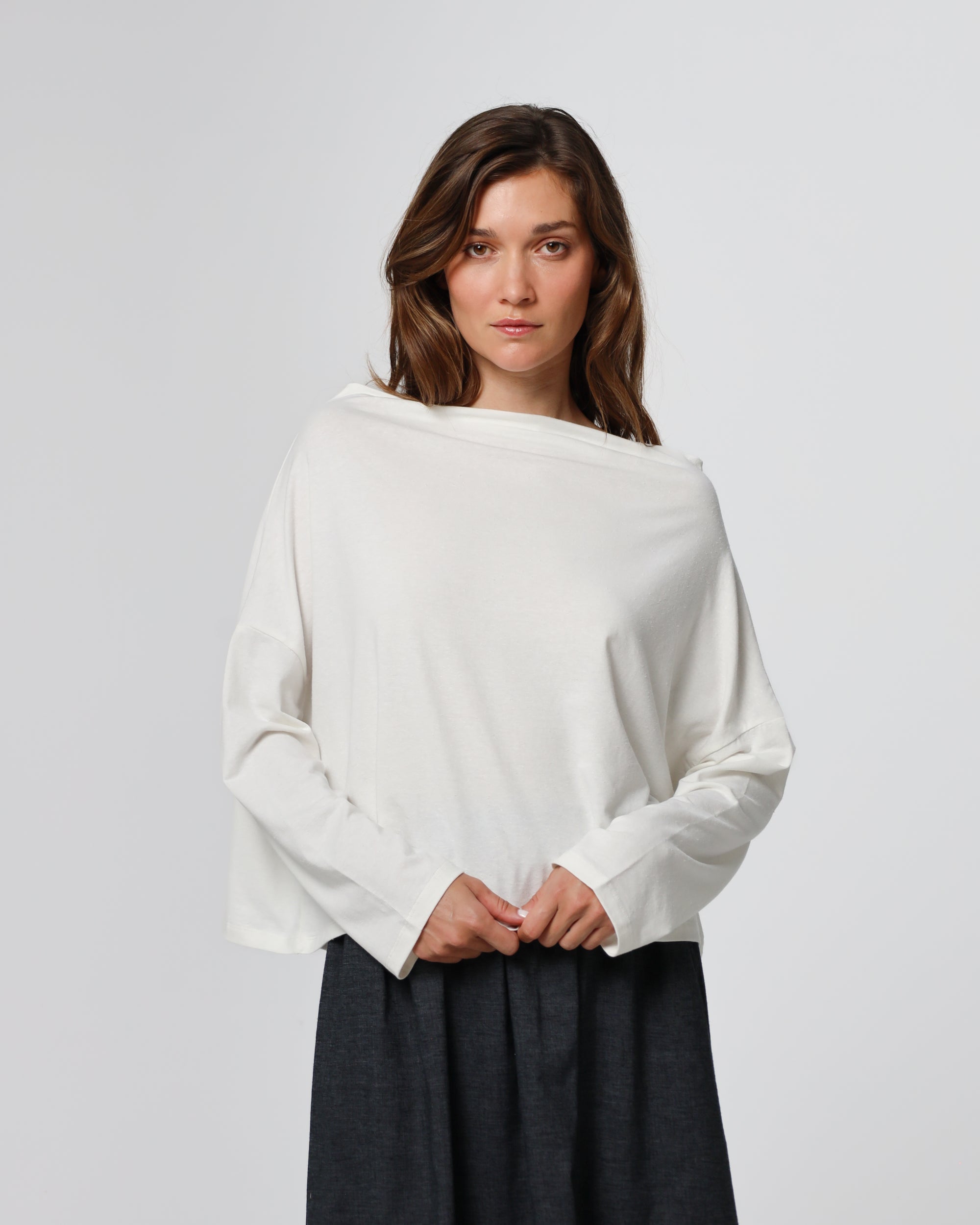 Woman wearing Juana Hemp Essentials Off The Shoulder Top in white hemp–Tencel™ blend, styled for sustainable everyday wear.