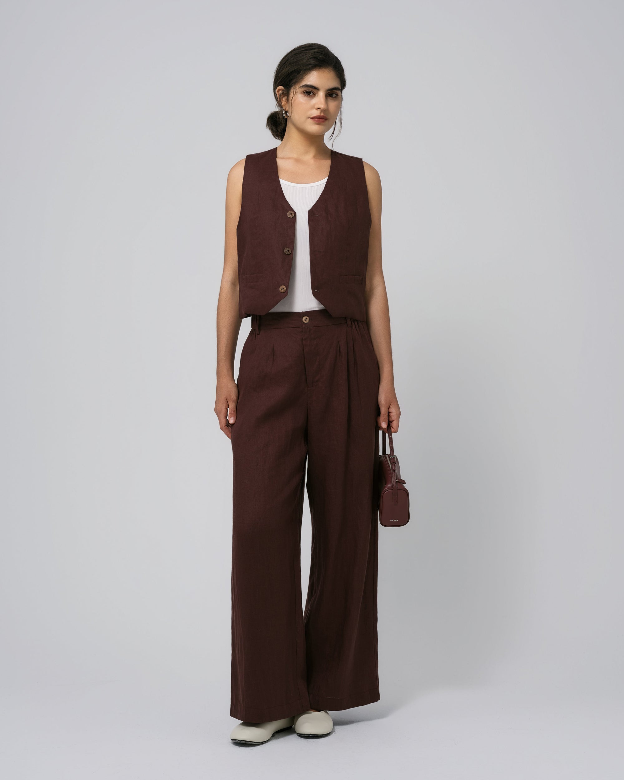 Model wearing Juana Hemp High Rise Pants in expresso (100% hemp) with corozo button closure; relaxed tapered leg.