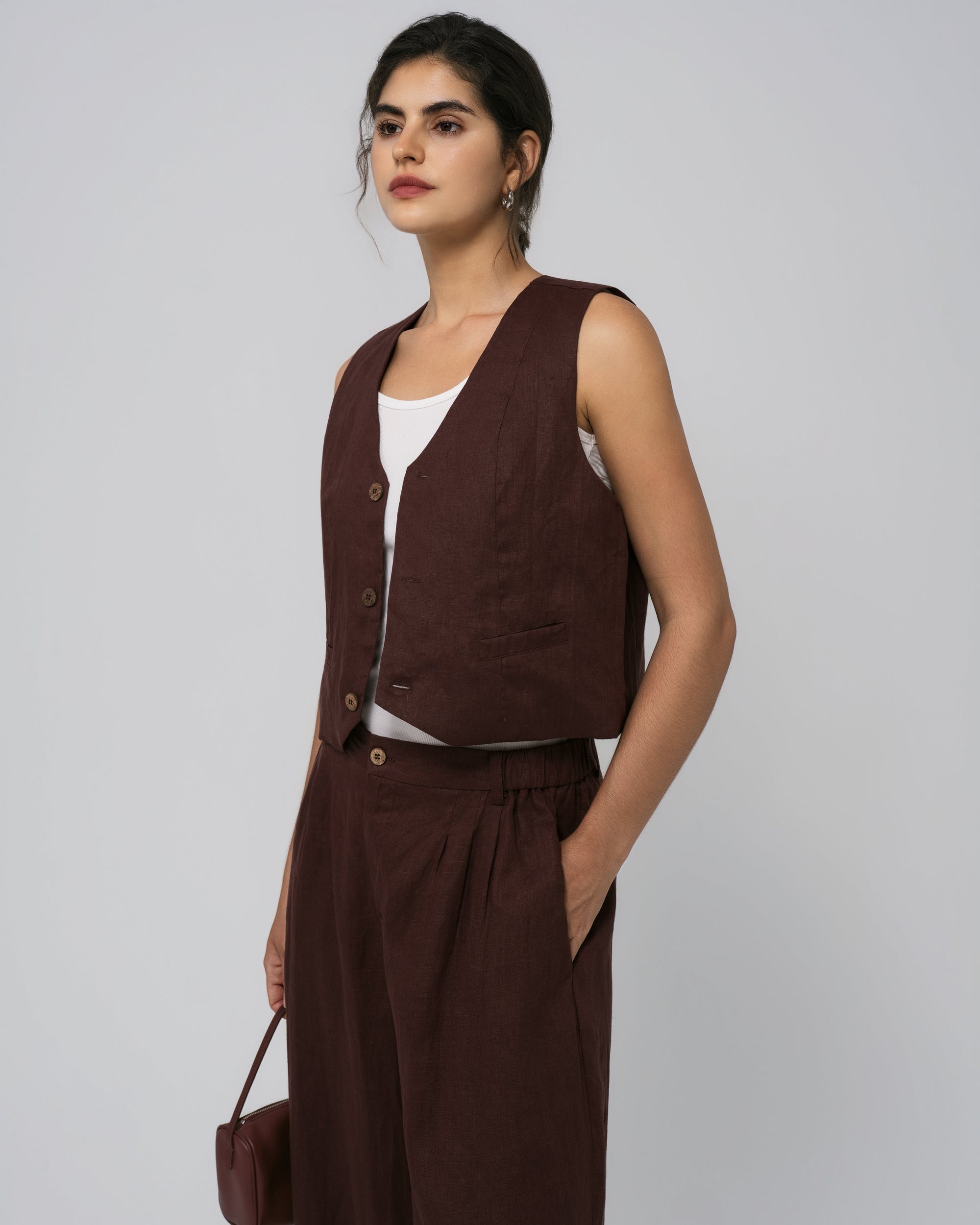 Model wearing Juana Hemp Tailored Vest in expresso (100% hemp) with corozo buttons; clean, minimalist silhouette.