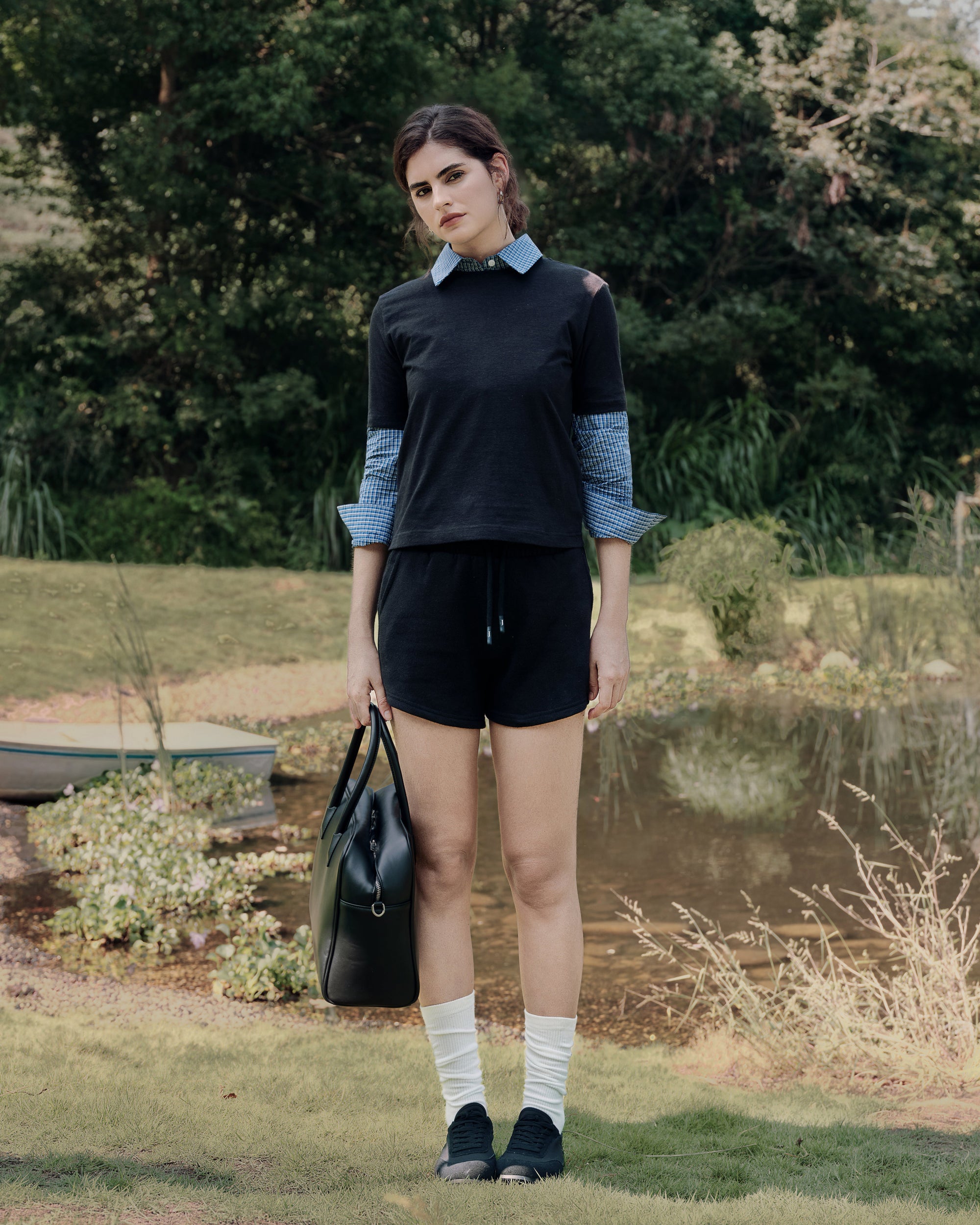 Garden standing shot of white hemp–organic cotton tee over blue shirt with gray fleece shorts; clean lines and casual polish.