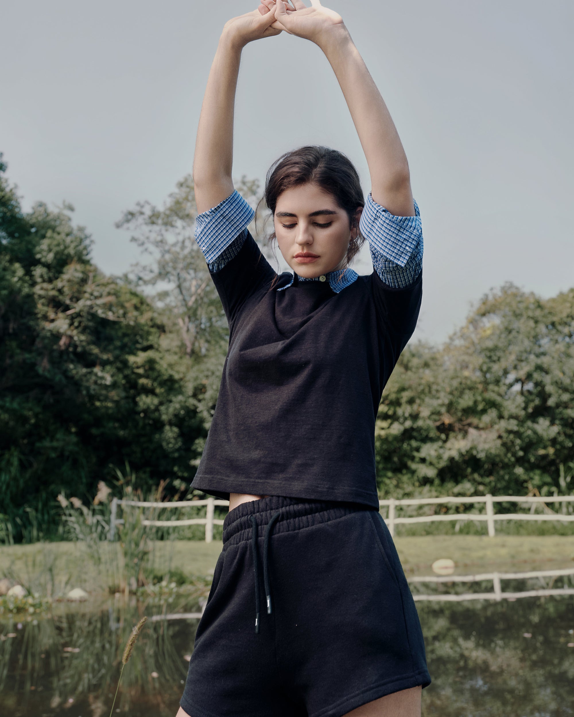 Lakeside back view of white tee over blue shirt with gray fleece shorts; relaxed silhouette and breathable layers.