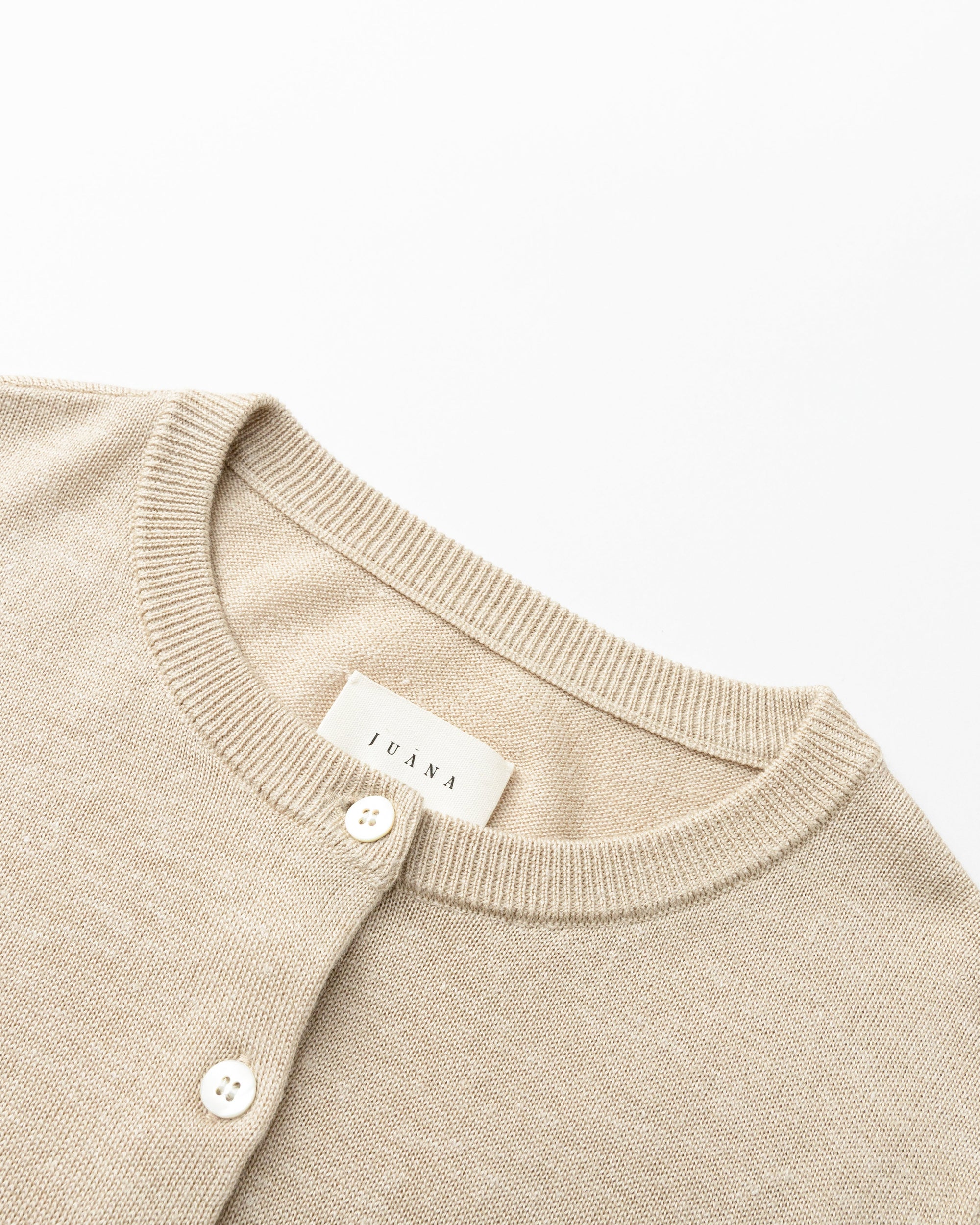 Detail shot of natural shell button placket and tailored rib finish on Liora Knitted Hemp Cardigan (beige).