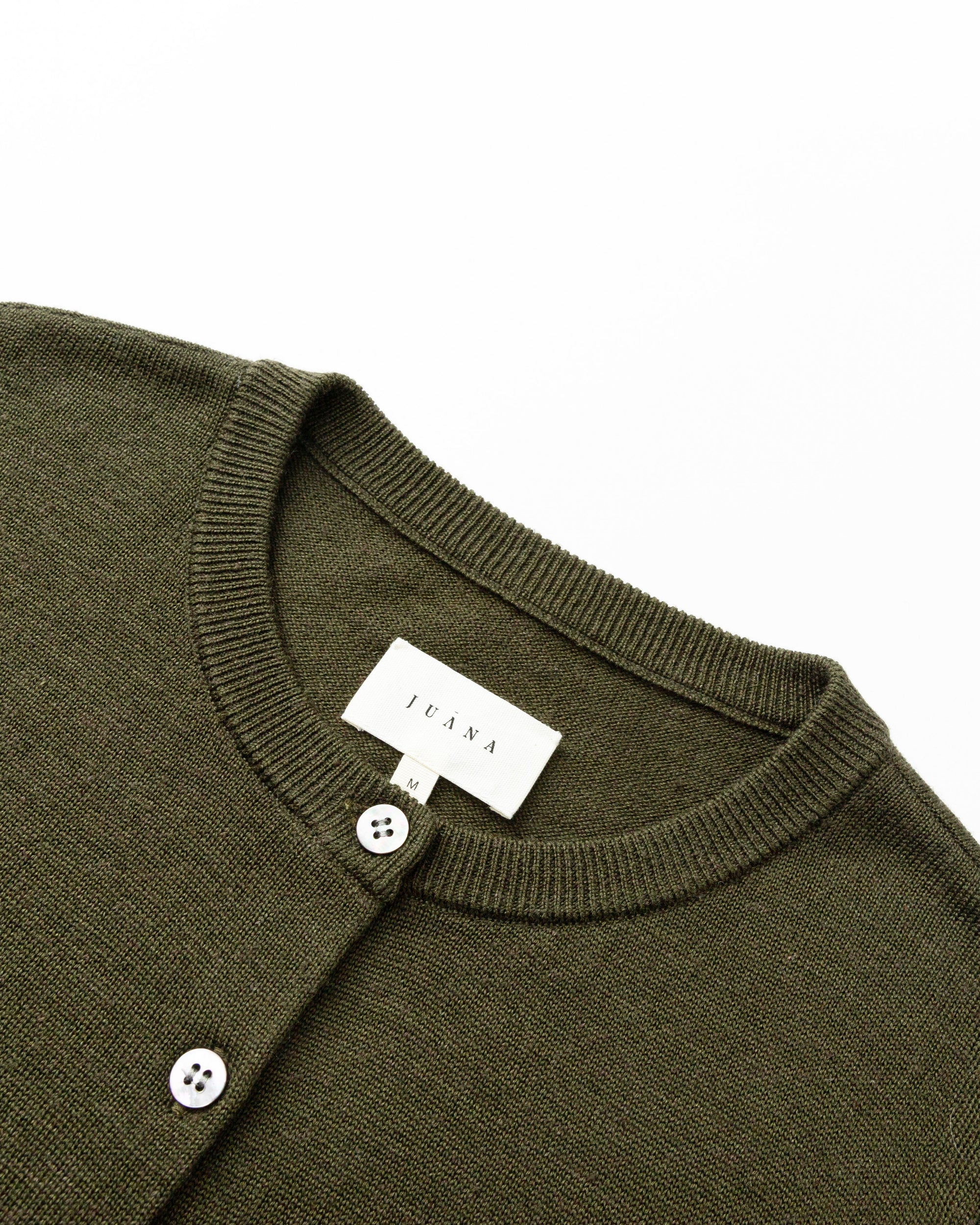 Detail shot of natural shell button placket and tailored rib finish on Liora Knitted Hemp Cardigan (camo green).