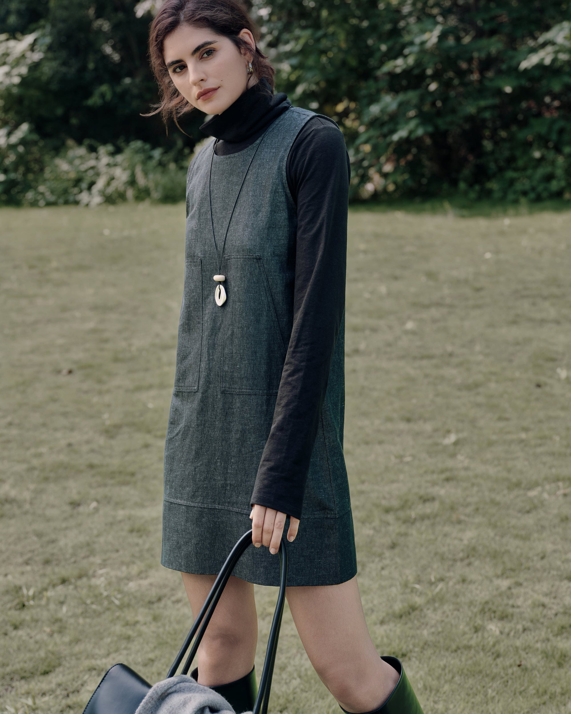 Layered styling: Mockneck (black) under Denim Atelier Shift Dress (black denim) with boots for minimalist polish.