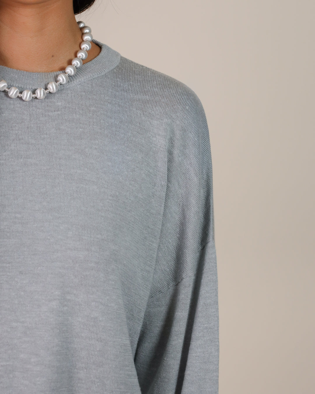 Woman wearing Juana Nilo Knitted Hemp Crewneck sweater fabric, showing texture and sustainable fiber details.