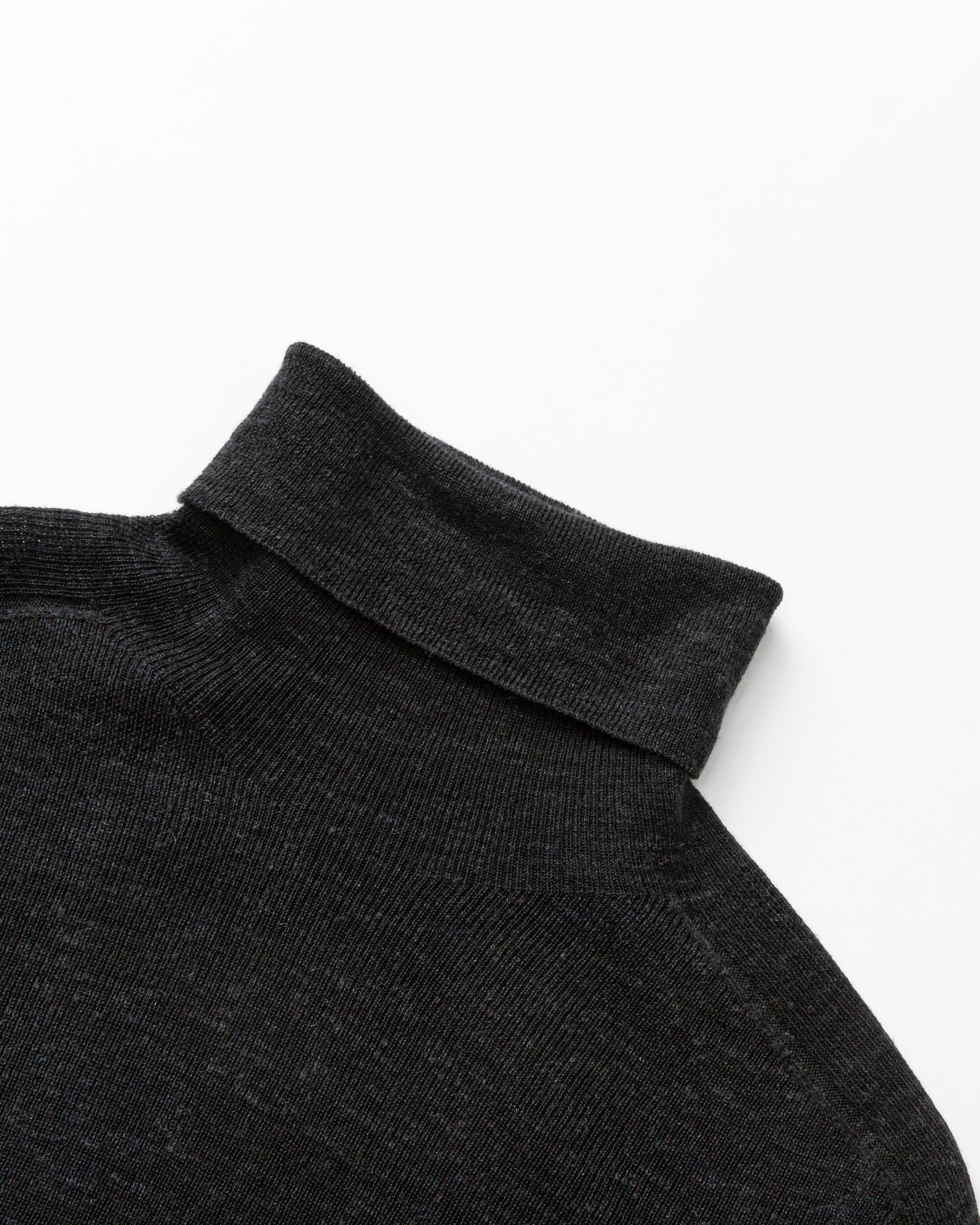 Detail shot of turtleneck collar, shoulder seam, and fine-gauge knit on Ossa Turtleneck (black).
