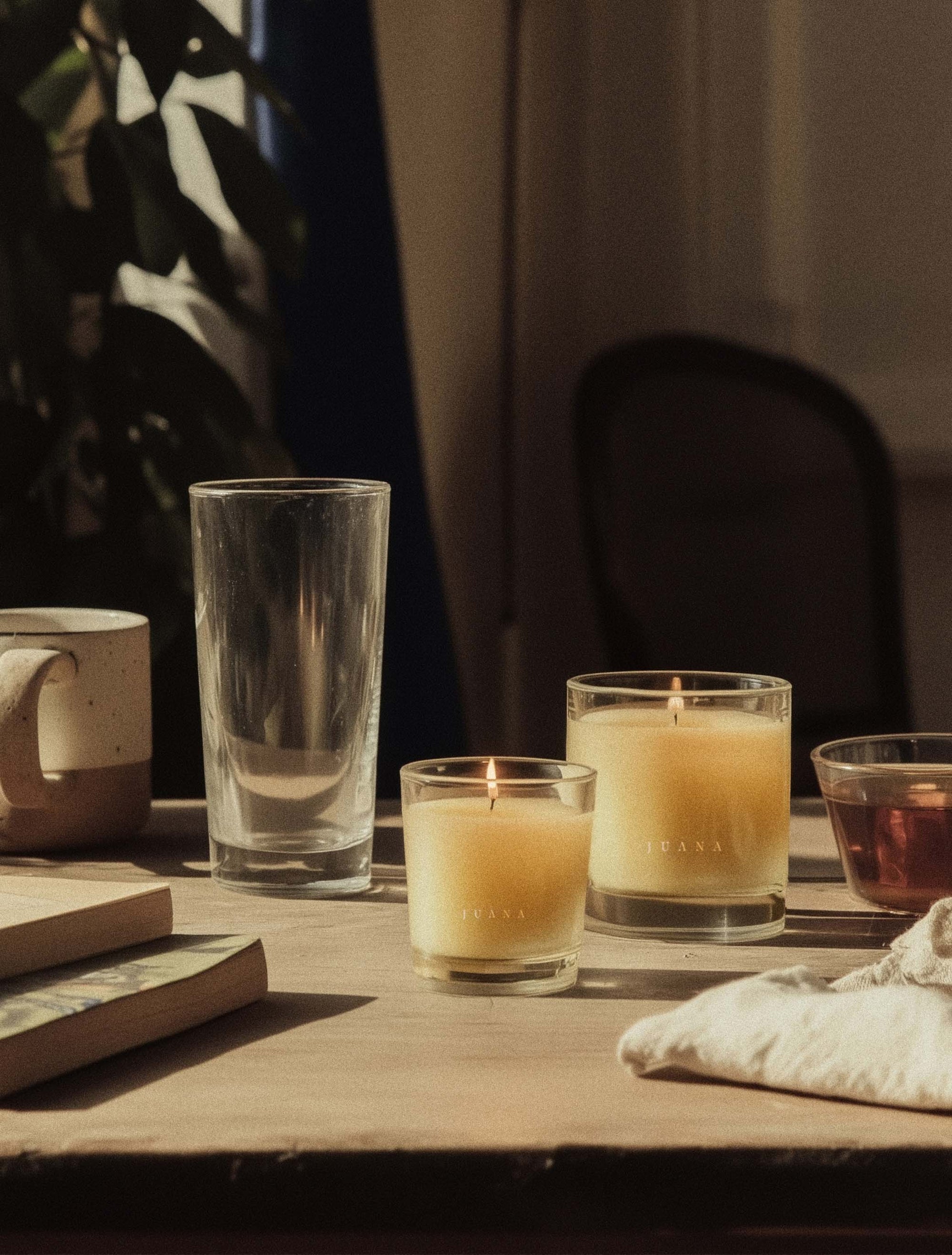 Juana Cypress + Mint Recovery apothecary candles in two sizes on decorated table, vegan and eco-friendly.