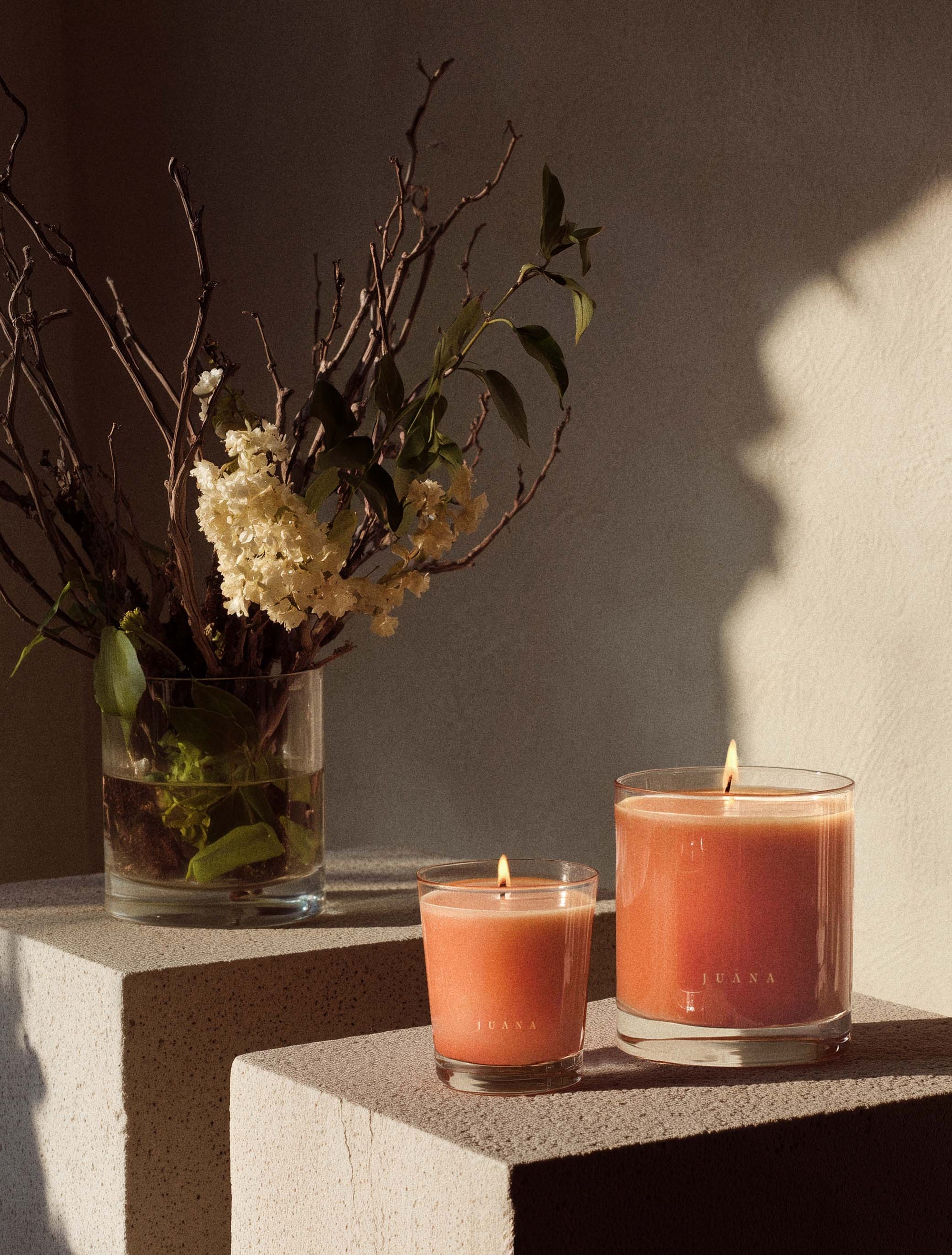 Juana Bergamot + Sativa Uplift apothecary candles in two sizes on decorated table, vegan and eco-friendly.