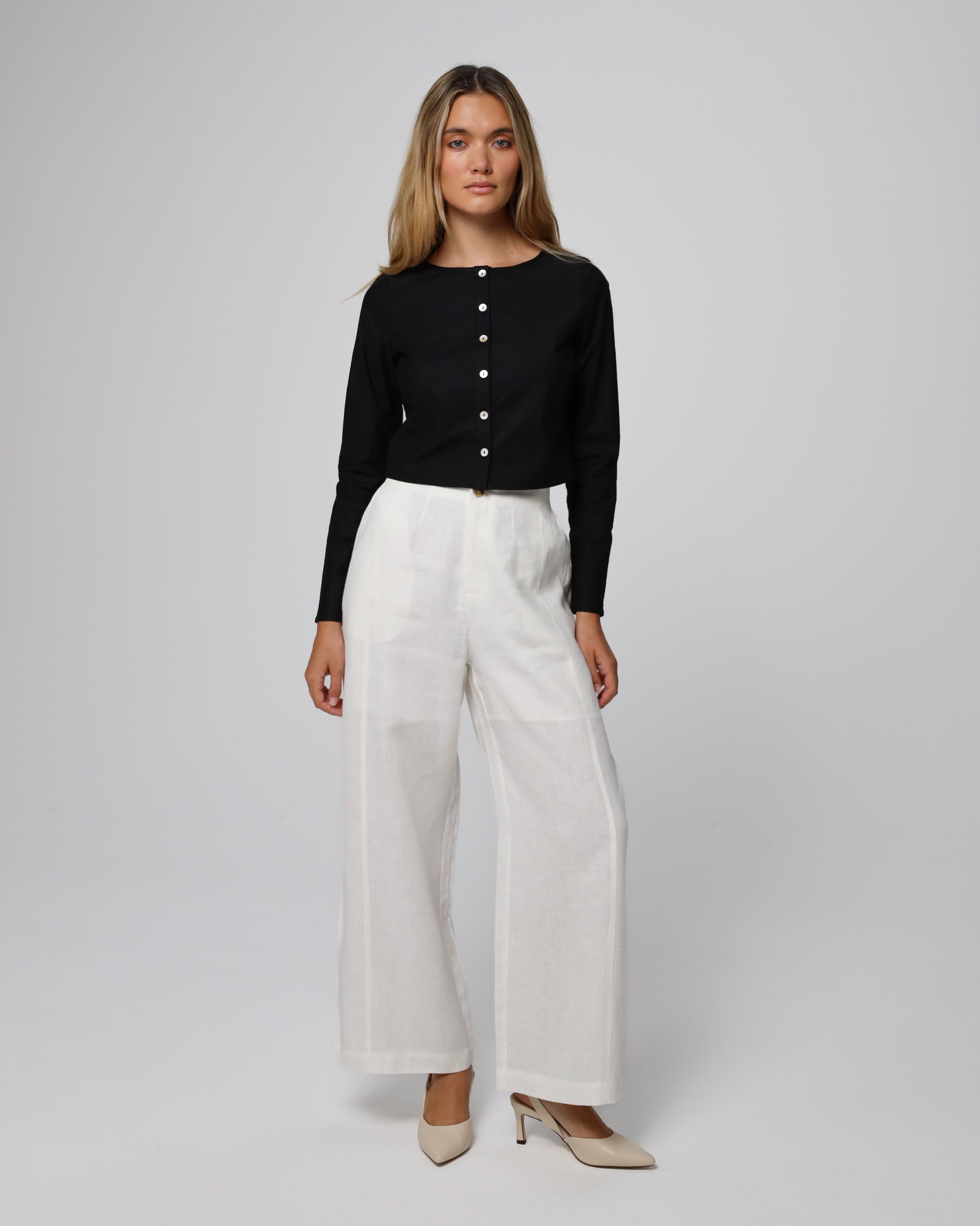 Woman wearing Juana Aella Long Sleeve Woven Top in a hemp–organic cotton blend (black), styled for sustainable everyday wear.