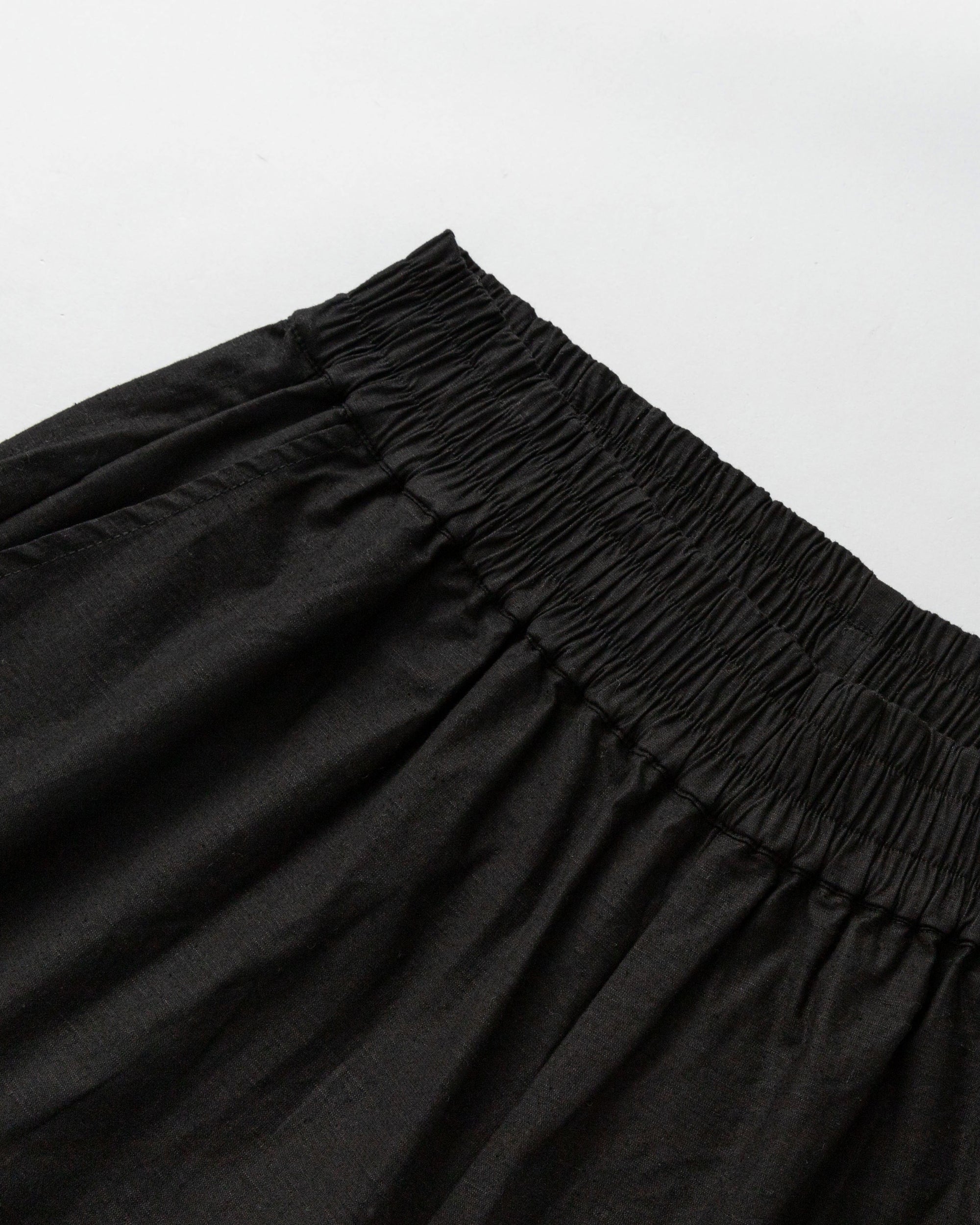 Detail shot of waistband and stitching on Aella Mid Rise Relaxed Tapered Pants (black).