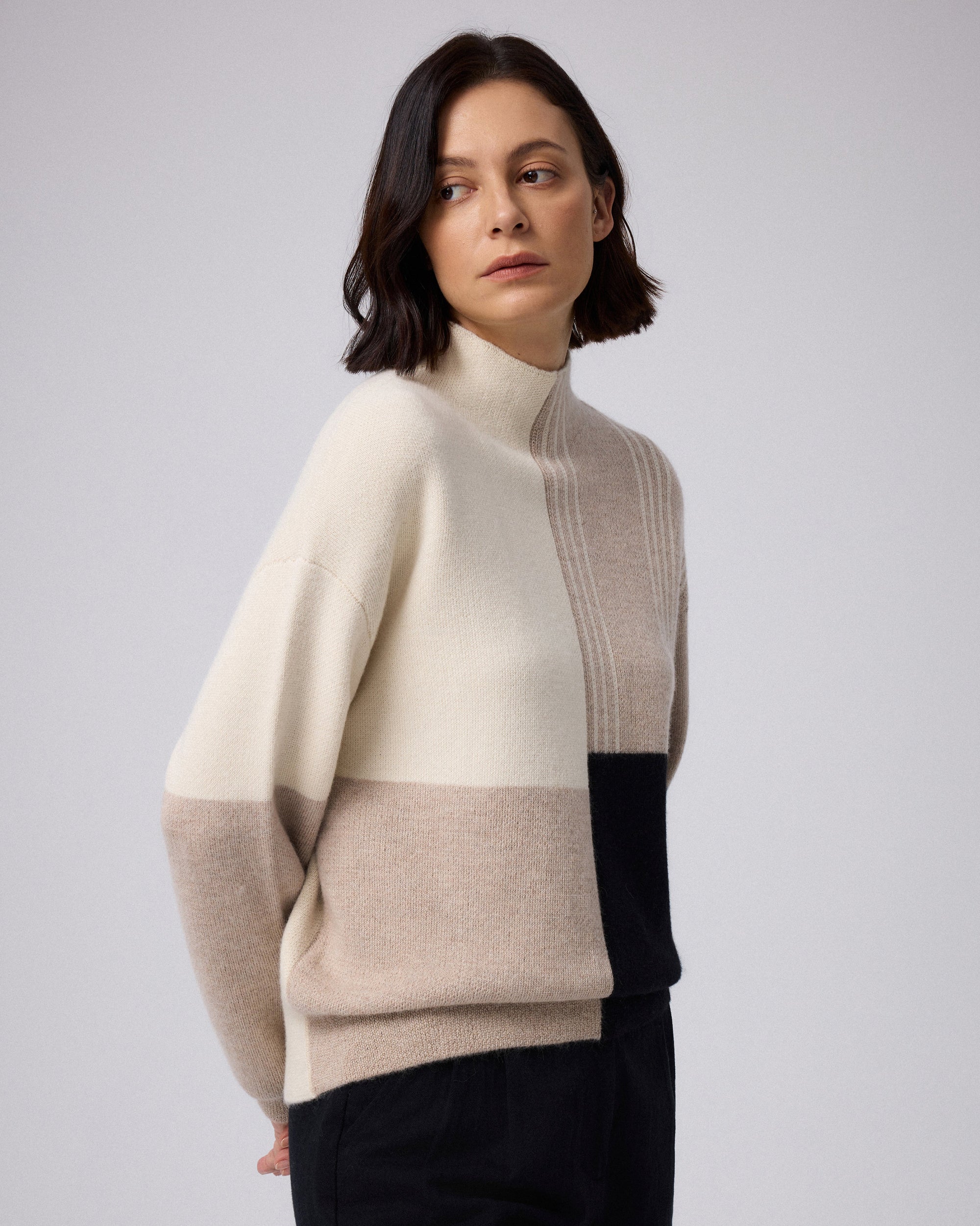 Juana Alpaca Crewneck Sweater in Cream/Black (baby alpaca wool–knit) shown from the side with a subtle high-low hem.