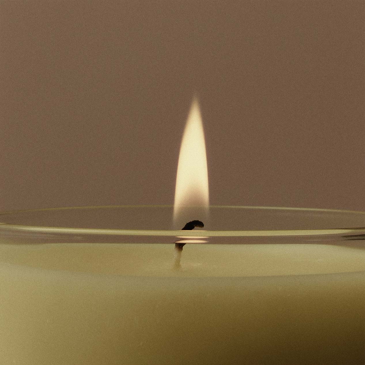 Juana hand-poured apothecary candle burning, minimalist design, sustainable wax, refined fragrance, crafted for well-being and mood elevation.