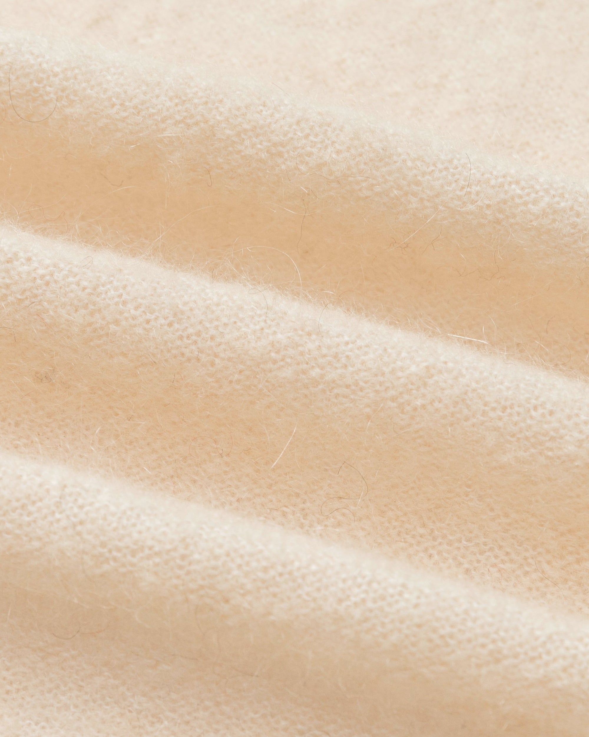 Textile close-up of almond milk wool–cashmere–hemp knit; soft handfeel and fine gauge.