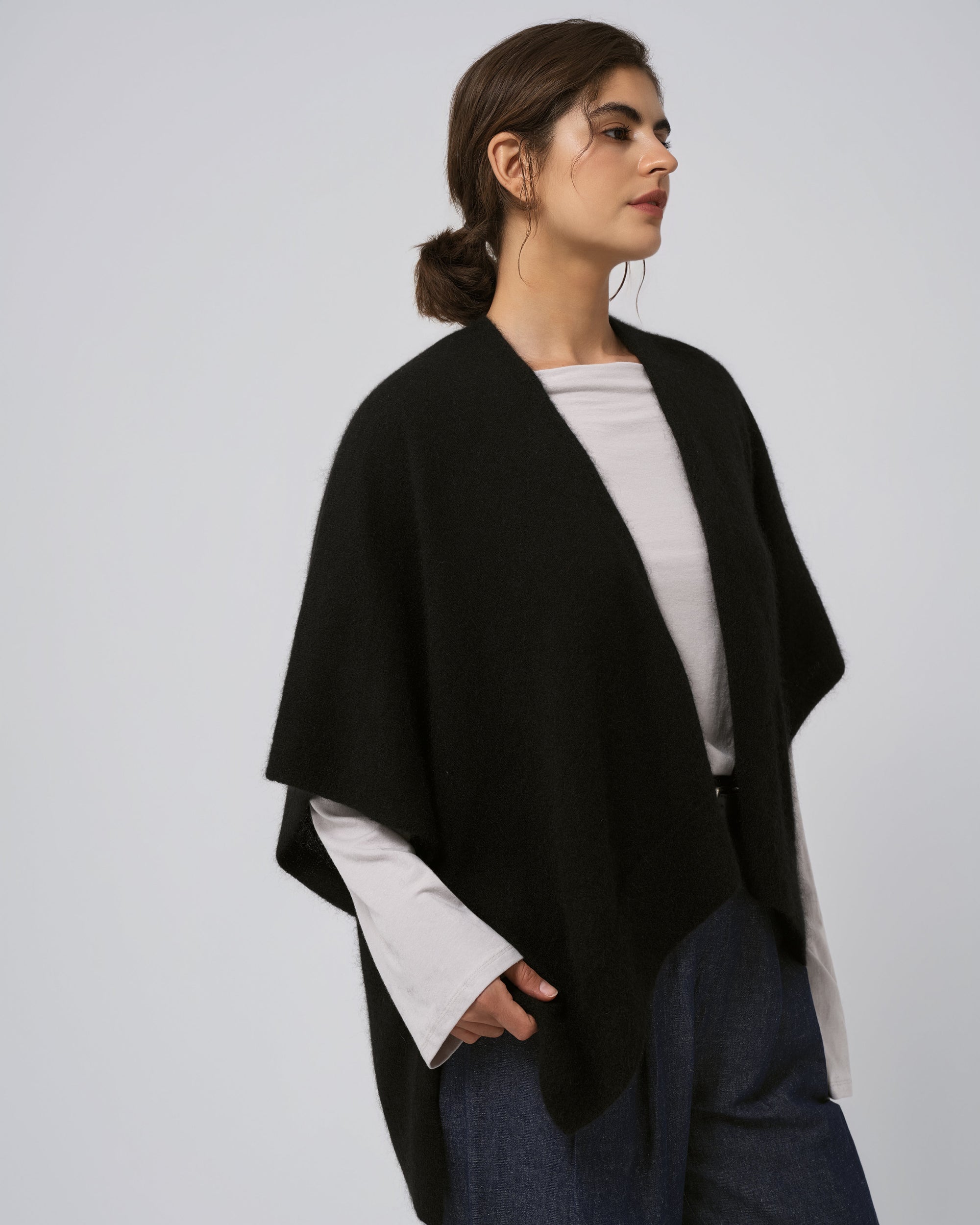 Detail of neckline and edge finish on black wool–cashmere–hemp cape; refined trim and drape.