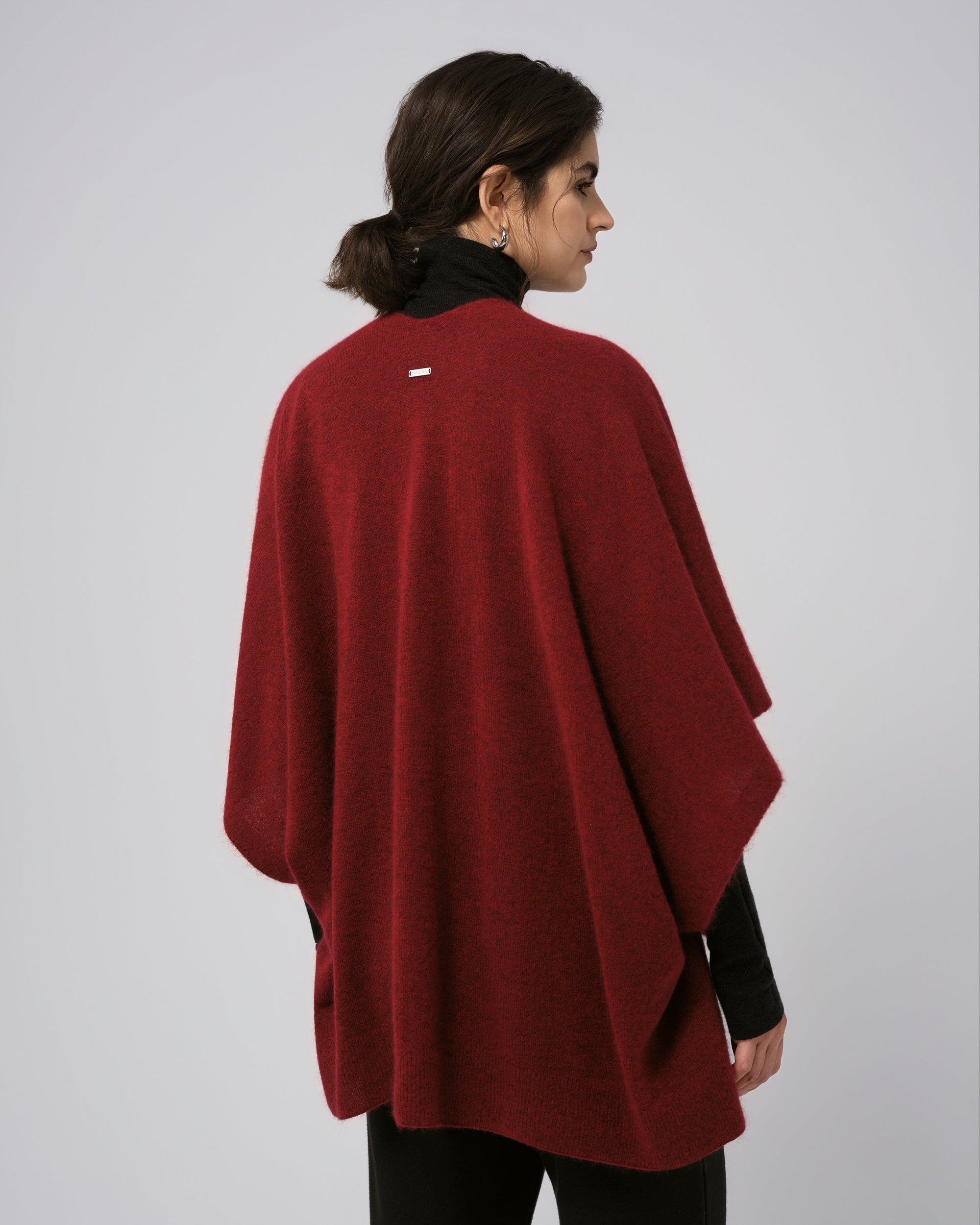 Model back view of burgundy cape; smooth back and flowing hem.
