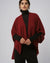 Model wearing Juana Cashmere Cape in burgundy (wool–cashmere–hemp knit), showing warm hue and elegant drape.