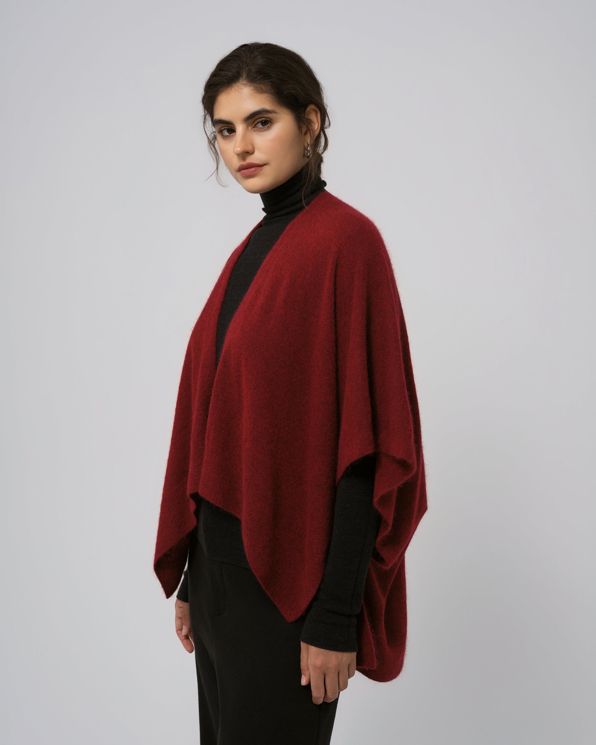 Model wearing Juana Cashmere Cape in burgundy; silhouette and edge finishing.