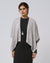 Model wearing Juana Cashmere Cape in light grey (wool–cashmere–hemp knit), showing airy drape and soft tonal texture.