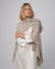 Woman wearing Juana Cashmere Cape in oatmeal wool–cashmere–hemp knit, showing fluid, sculptural drape.
