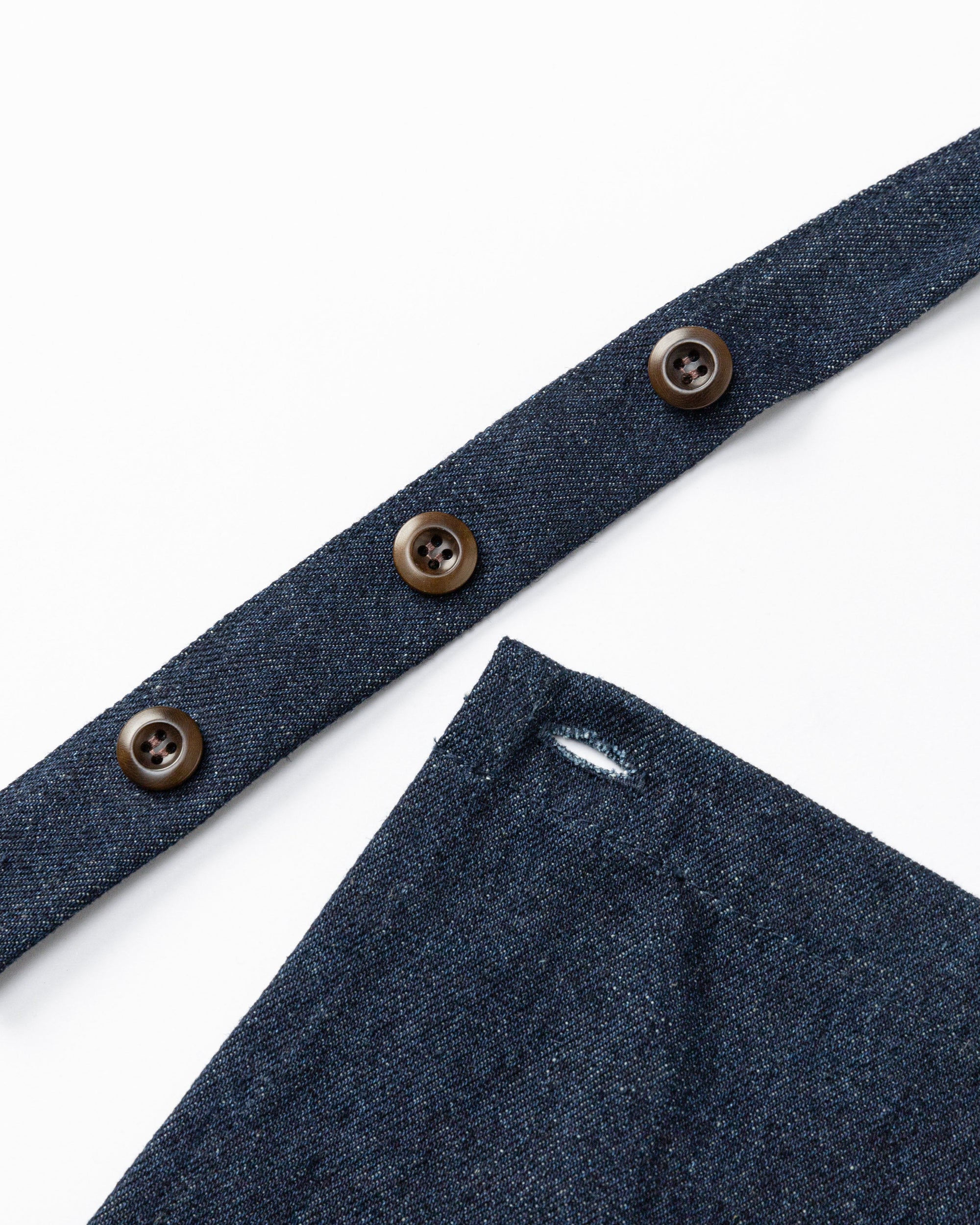Flat lay of Denim Atelier Functional Apron (indigo), showing adjustable strap configuration.