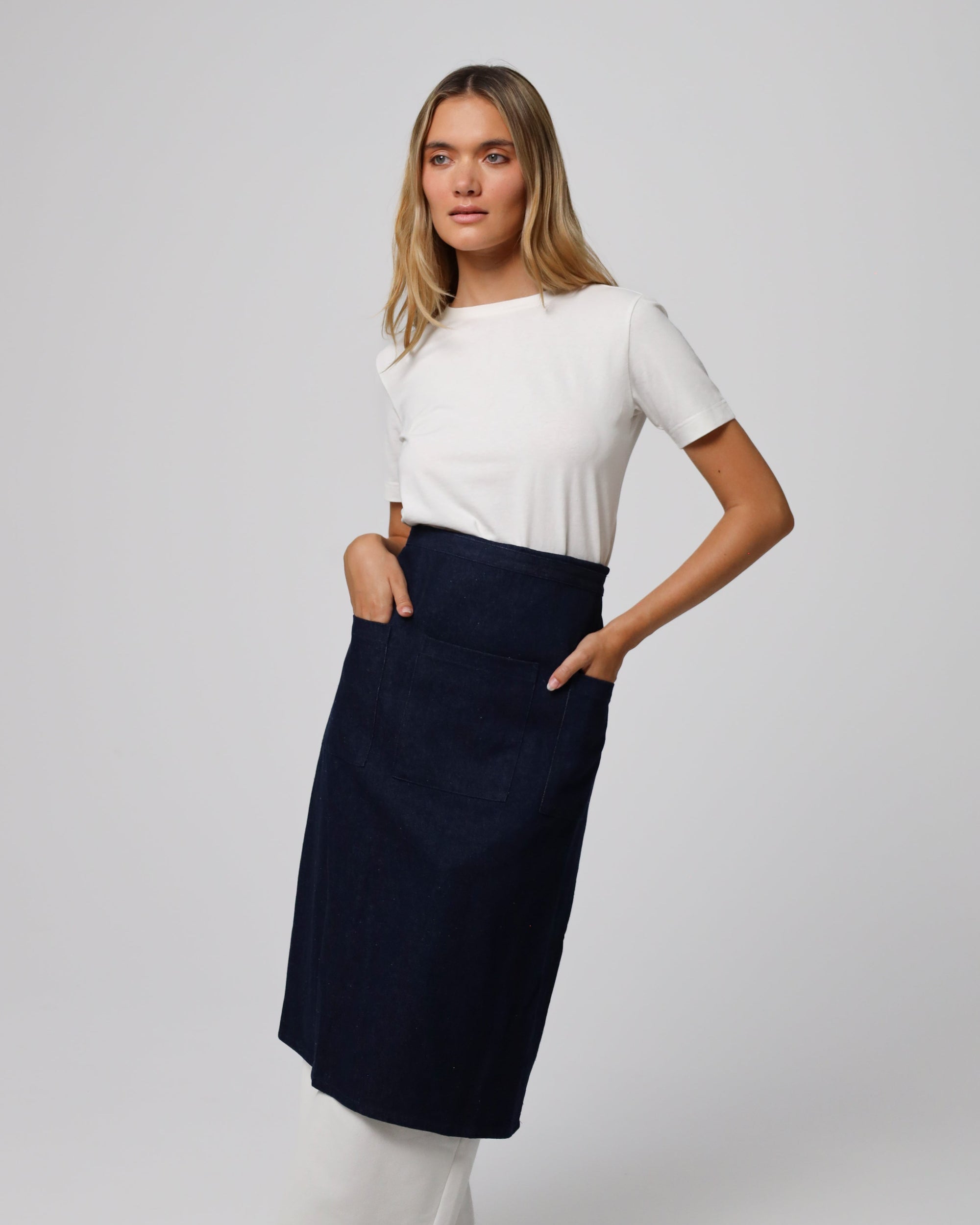 Model demonstrating apron (indigo) with pockets, showcasing a wear when folded.