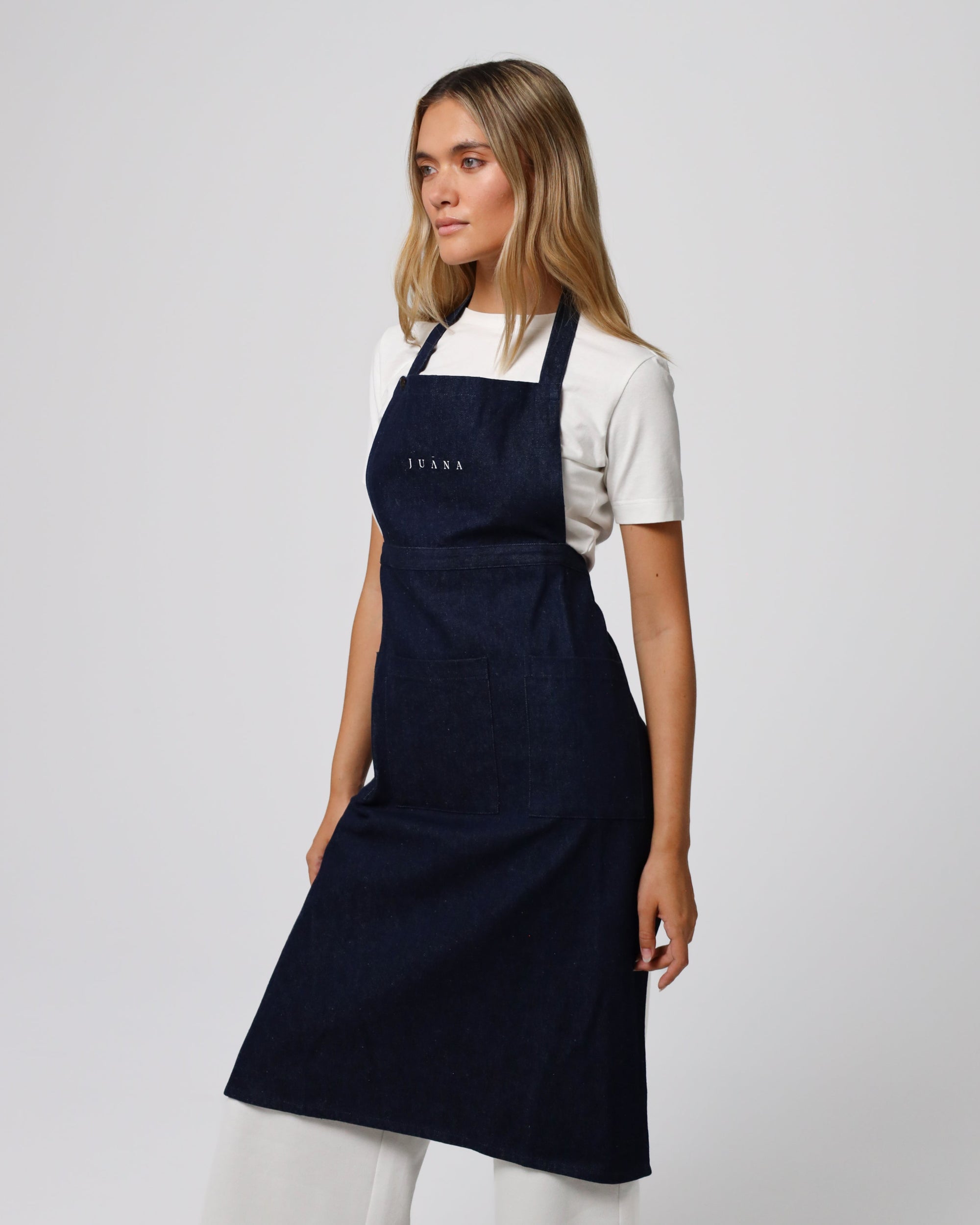 Model wearing Juana Denim Atelier Functional Apron in indigo hemp–organic cotton denim, styled for everyday utility.