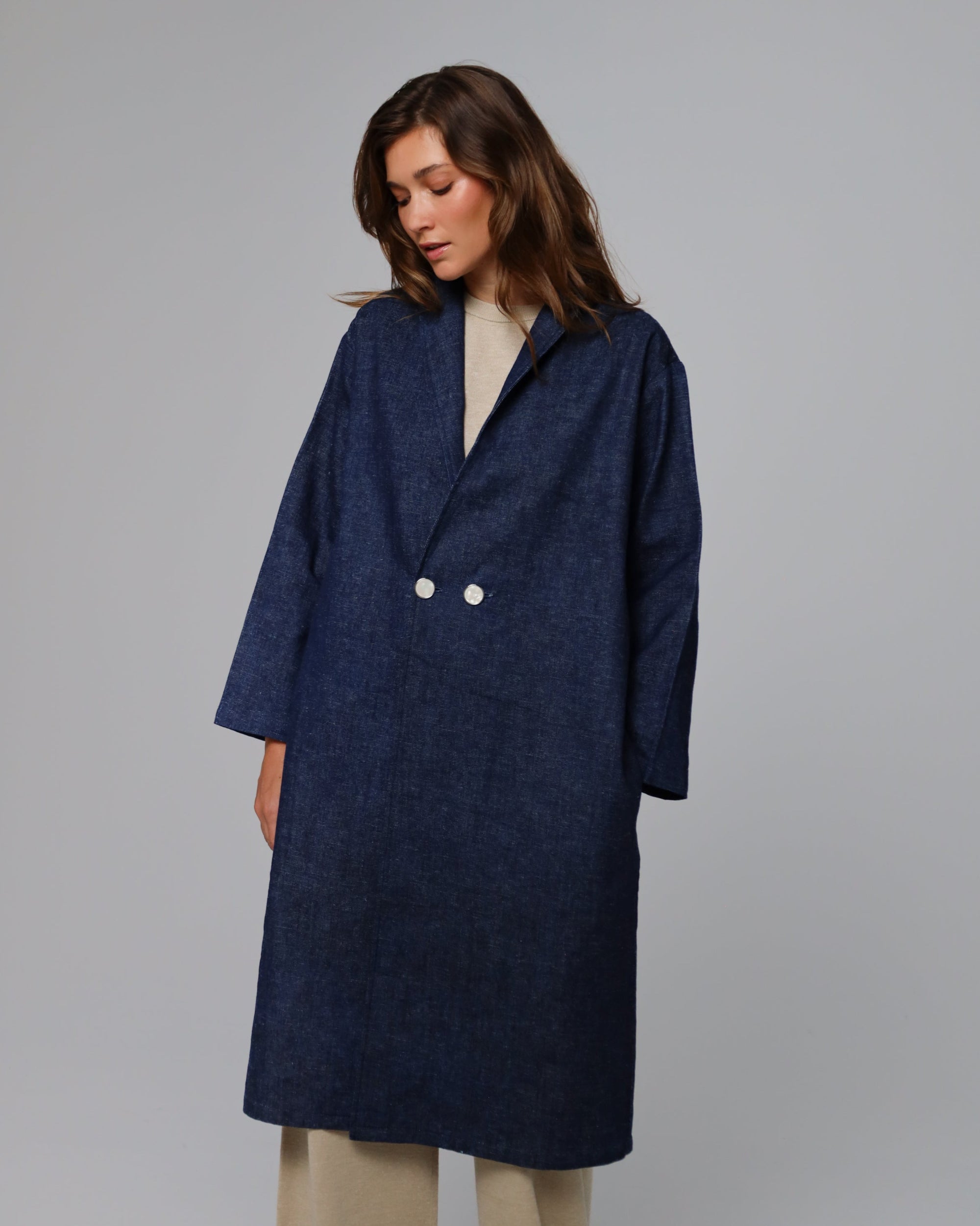 Model styling Denim Atelier Trench Coat (indigo denim) over knitwear for refined daytime ease.