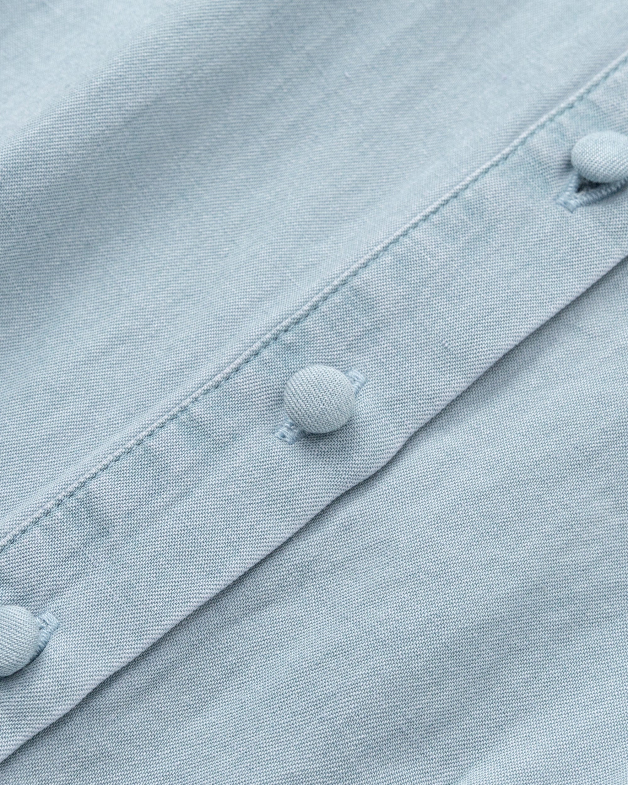Juana Faye Pleated Shirt Dress chambray blue (Tencel–cotton–hemp blend) detail layflat showing covered buttons and pleating