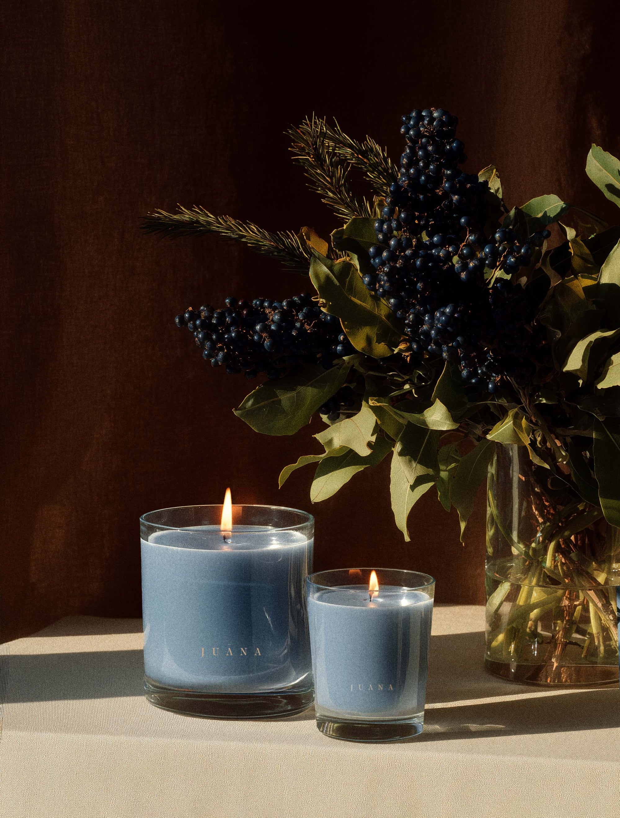 Juana Cassis + Rosemary Focus apothecary candles in two sizes on decorated table, vegan and eco-friendly.