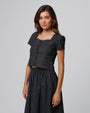 Woman wearing Juana Hemp Blend Button Front Top in washed black hemp–recycled stretch twill, showing clean neckline and sculpted fit.