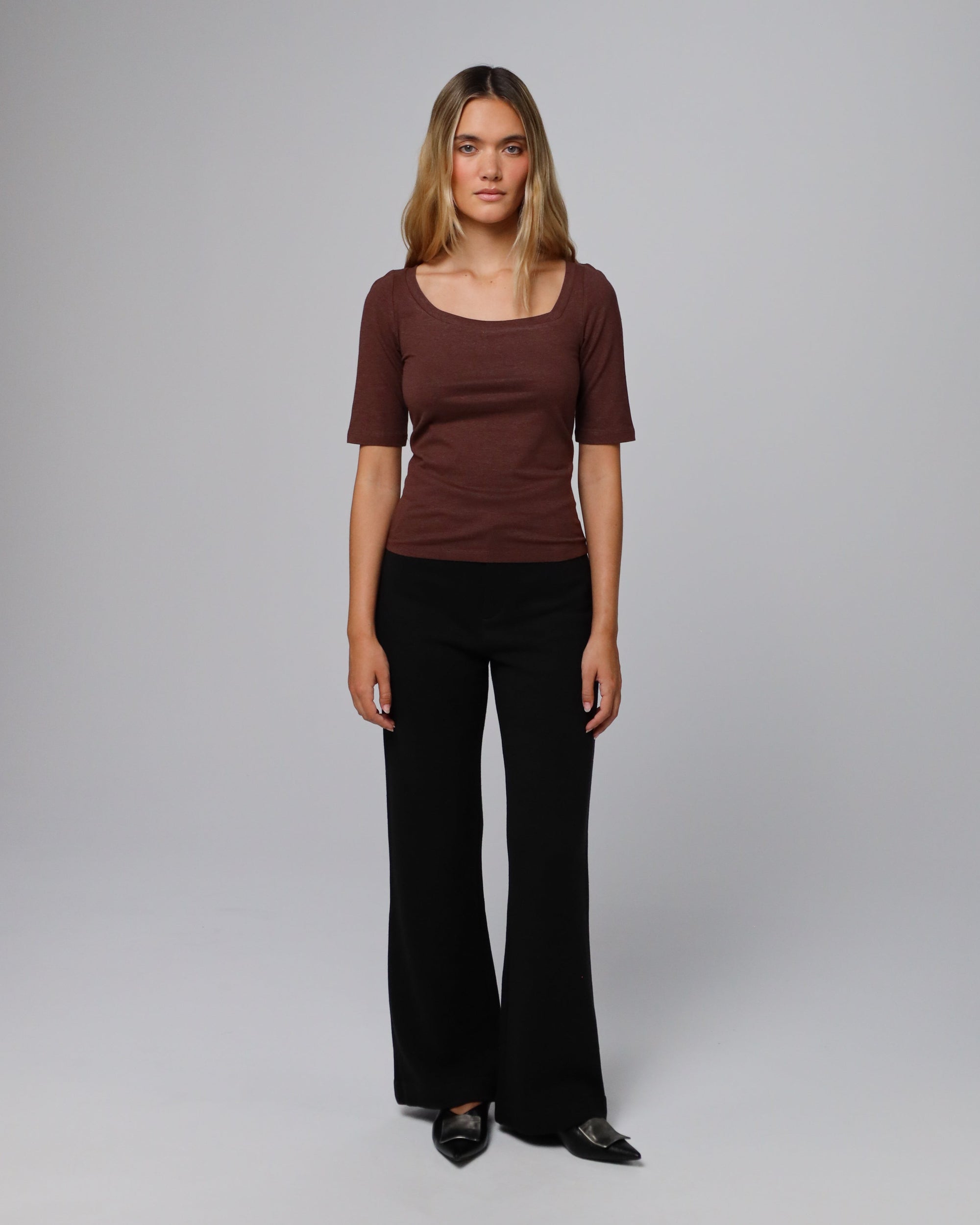 Model styling Asymmetrical Neckline Tee (cacao) with tailored trousers for minimalist polish.
