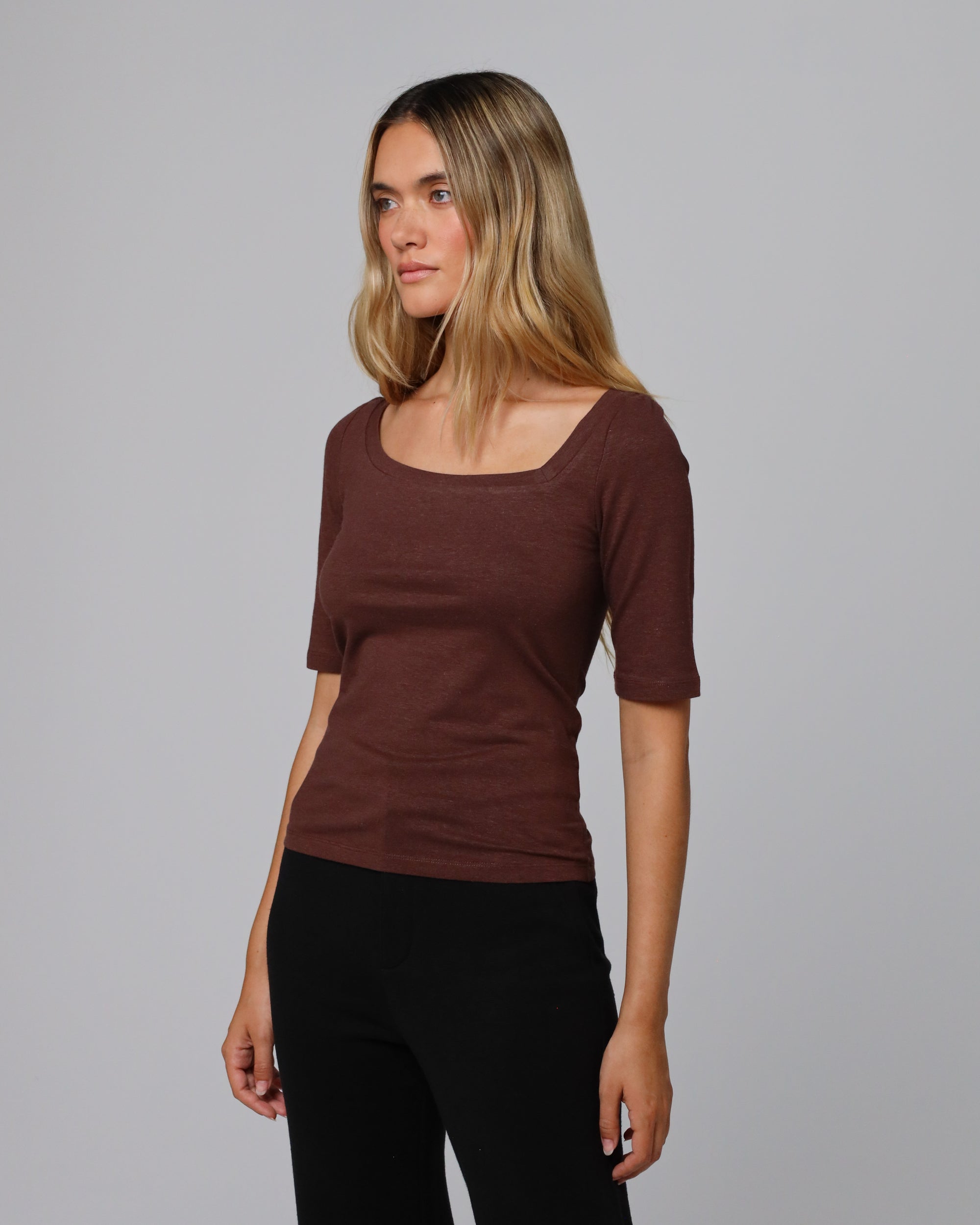 Woman wearing Juana Hemp Essentials Asymmetrical Neckline Tee in cacao hemp–organic cotton stretch blend, styled for sustainable everyday wear.