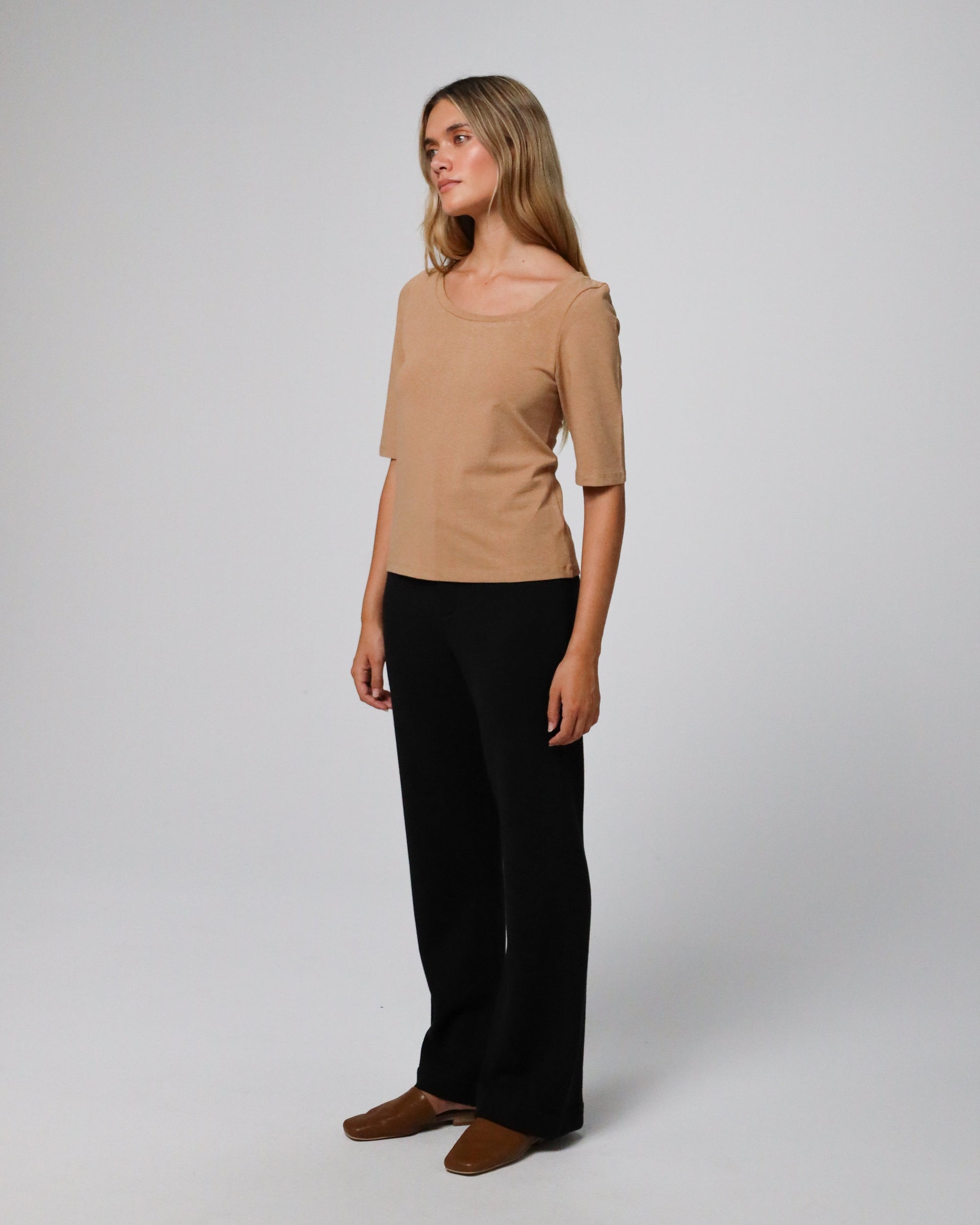 Woman wearing Juana Hemp Essentials Asymmetrical Neckline Tee in fawn hemp–organic cotton stretch blend, styled for sustainable everyday wear.