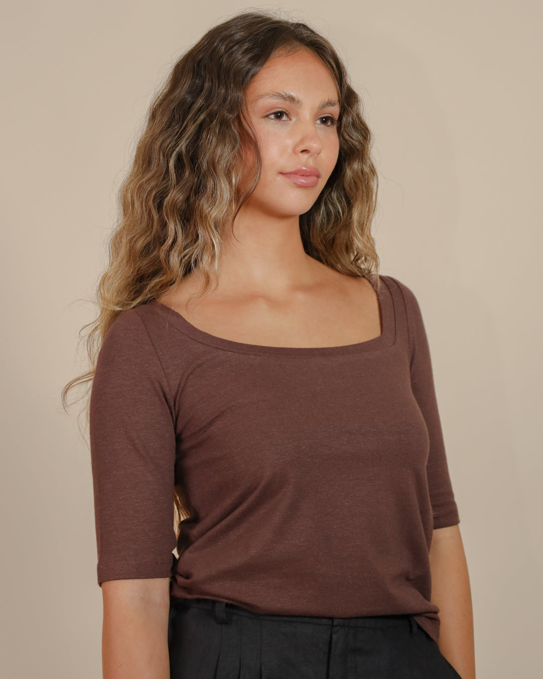 Close-up of the asymmetrical neckline and shoulder finish on the tee, showing craftsmanship and fabric texture.
