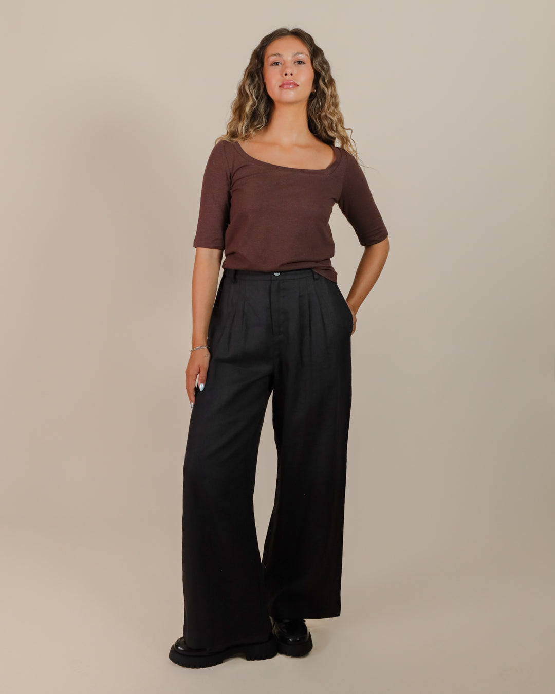 Model styling the Asymmetrical Neckline Tee with tailored trousers for an elevated, eco-friendly everyday look.