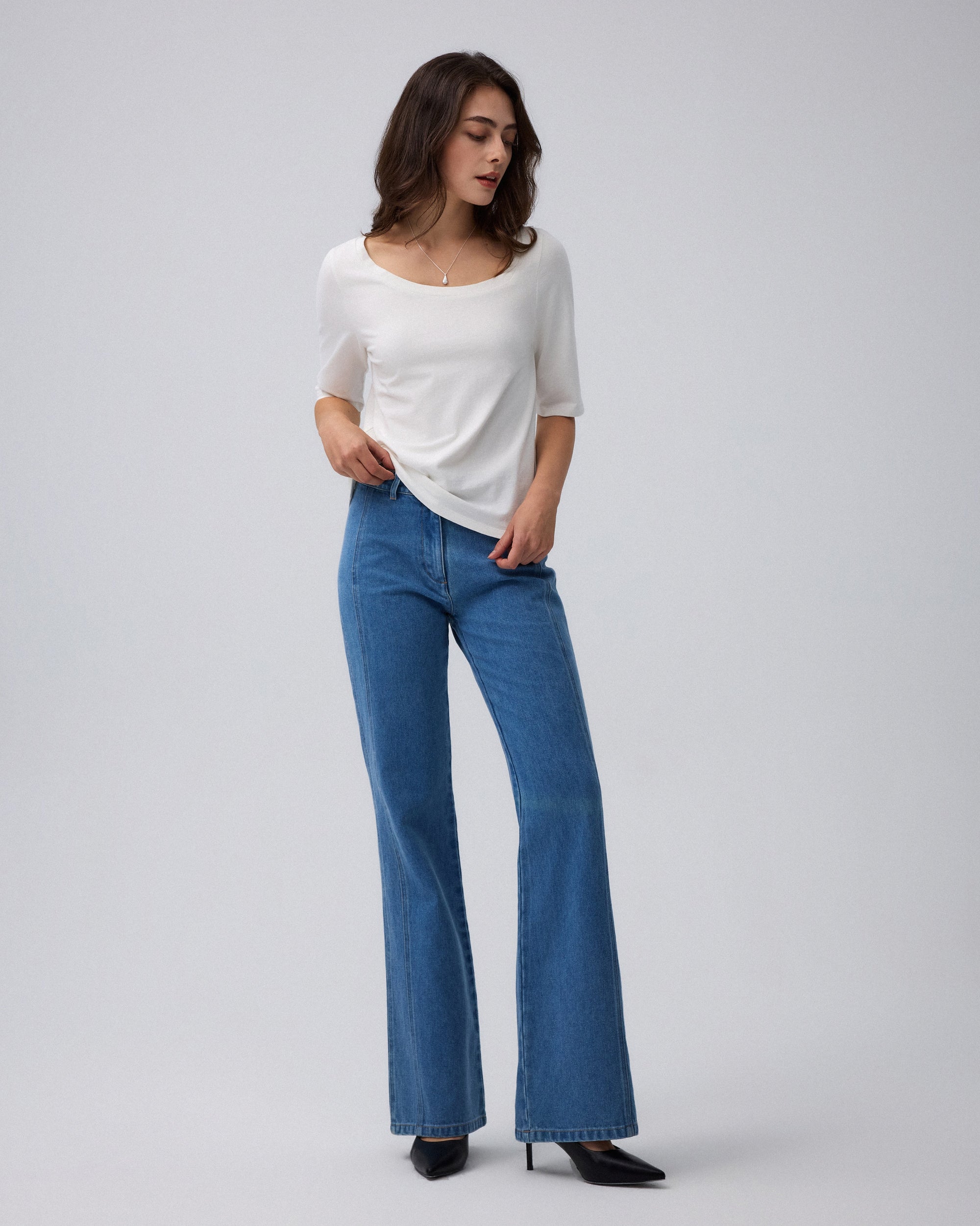 Woman wearing Juana Hemp Essentials Asymmetrical Neckline Tee in white hemp–organic cotton stretch blend, styled for sustainable everyday wear.