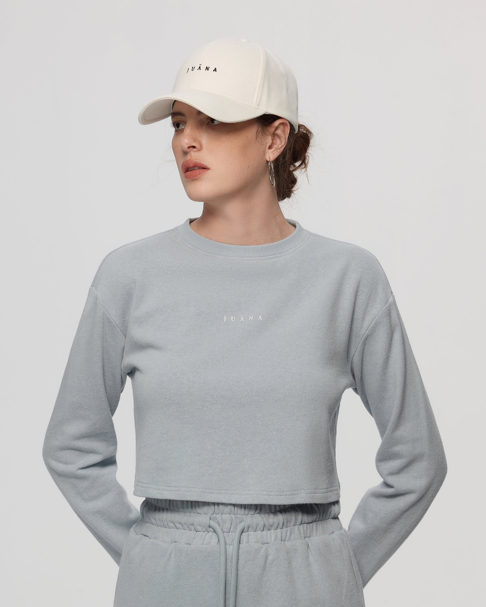 Woman wearing Juana Hemp Essentials Cap in white organic-cotton–hemp blend, styled for sustainable everyday wear.