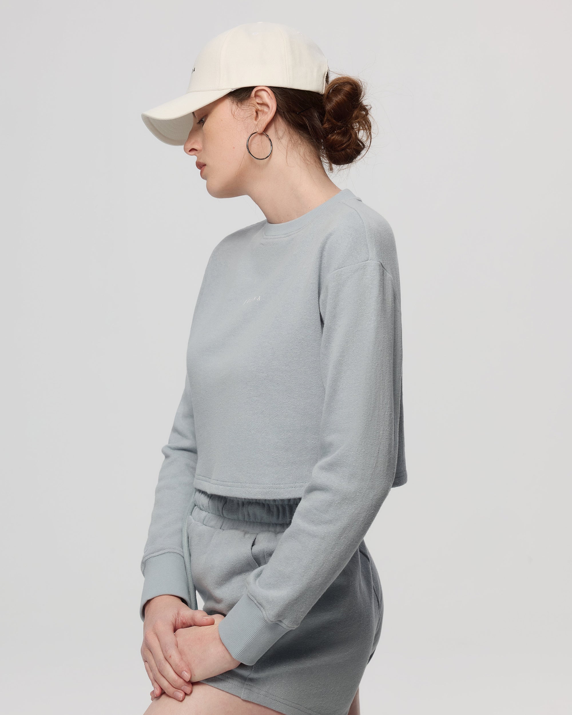 Side shot of brim stitching, panel seams, and adjustable back strap on the Hemp Essentials Cap (white).