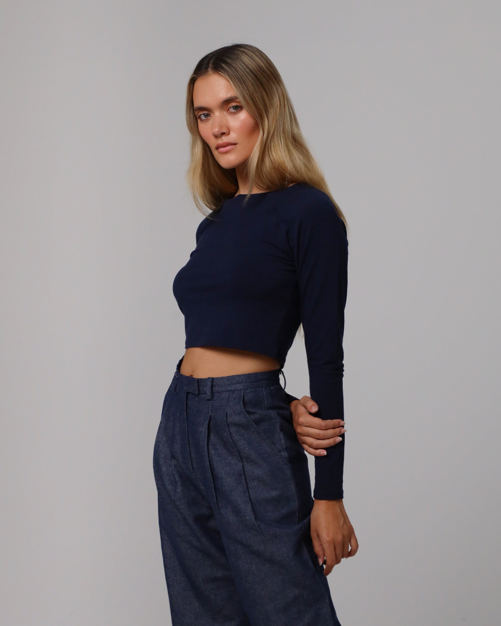 Woman wearing Juana Hemp Essentials Cropped Raglan Tee in indigo blue hemp–organic cotton stretch blend, styled for sustainable everyday wear.