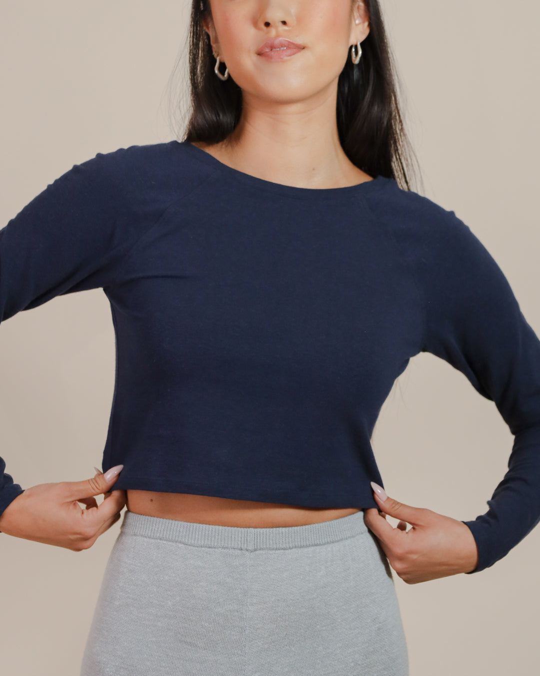 Close-up of raglan sleeve seam and cropped hemline, showing craftsmanship and fit details.
