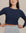 Close-up of raglan sleeve seam and cropped hemline, showing craftsmanship and fit details.