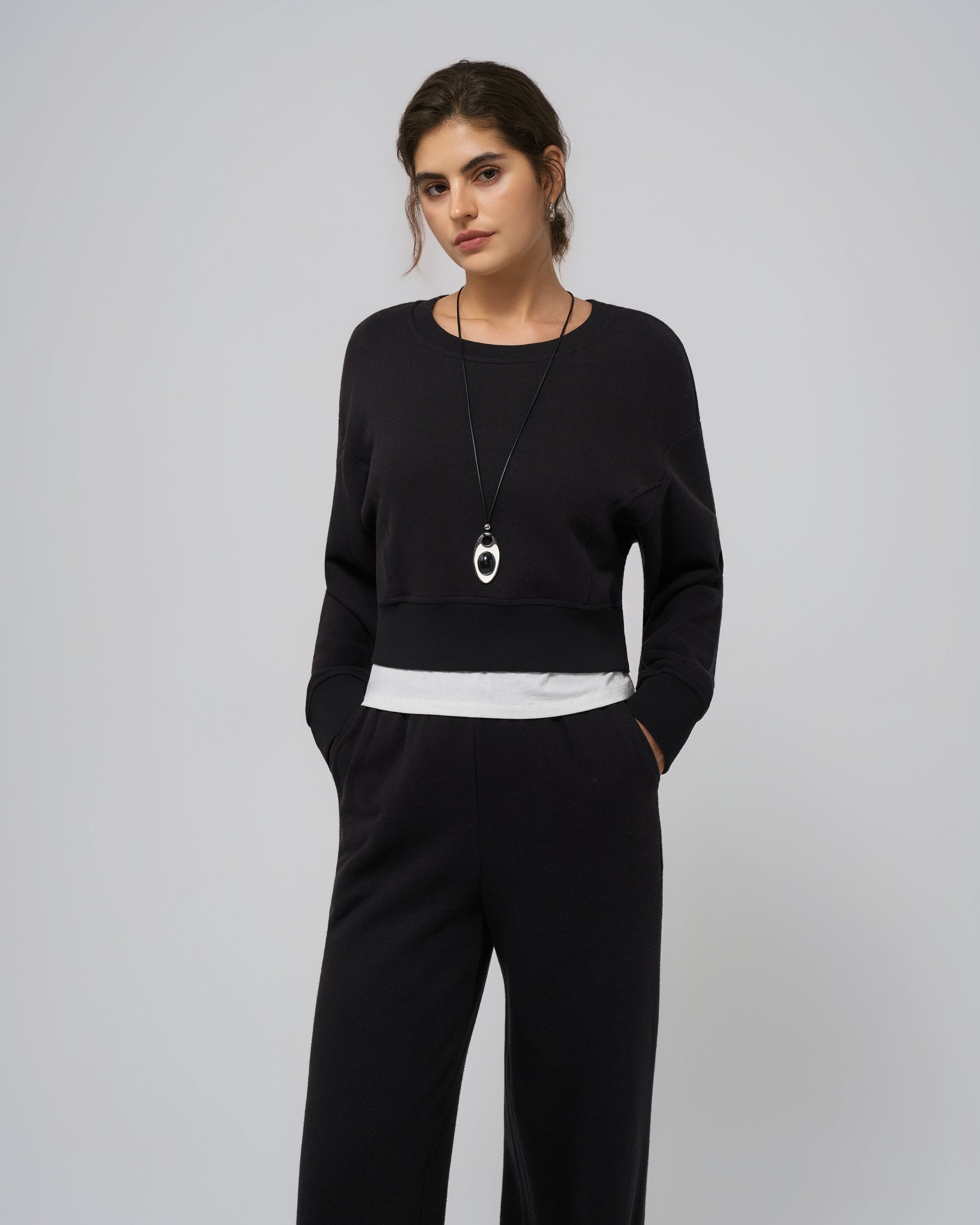 Full outfit with black cropped sweater; lounge to street styling.