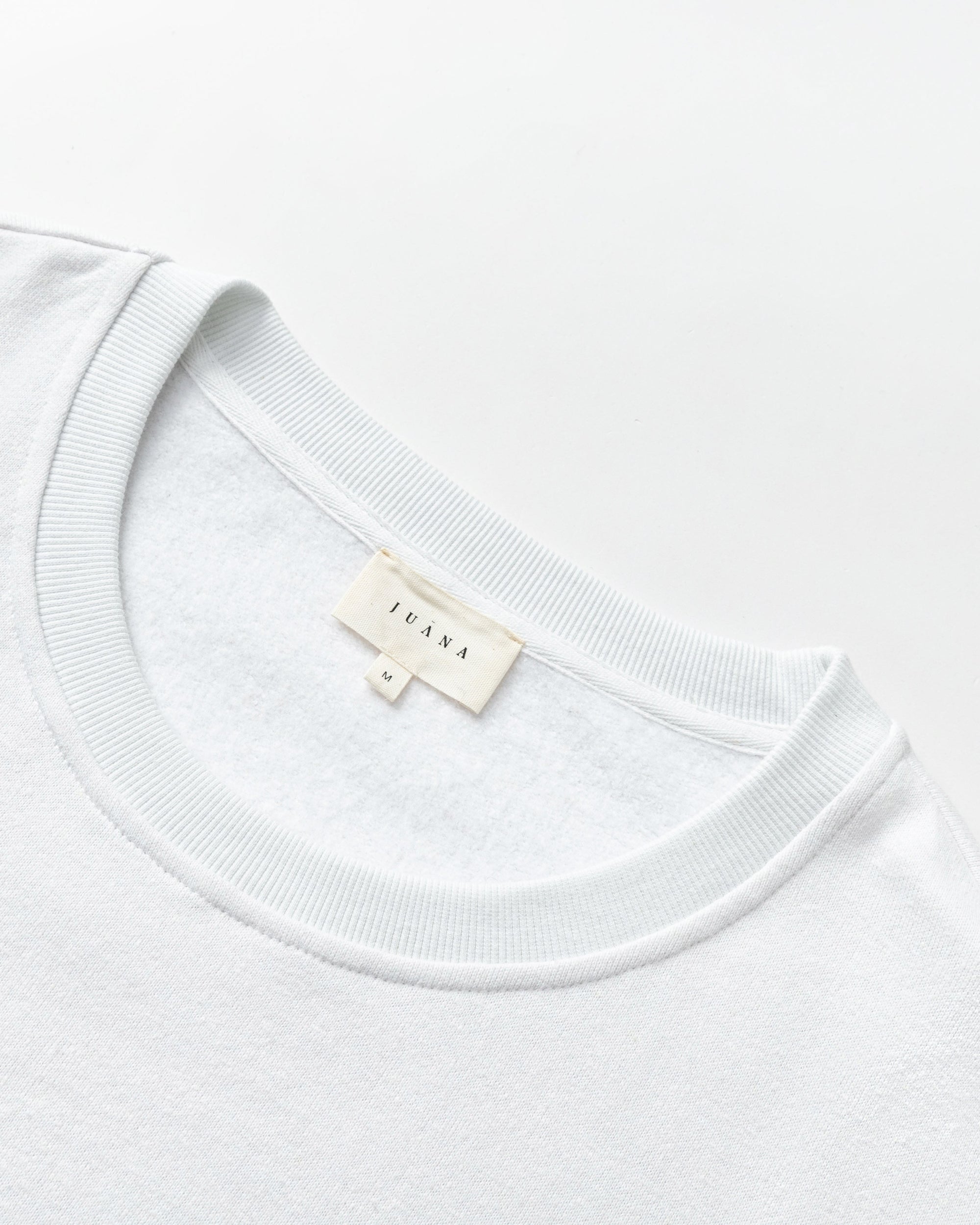 Detail shot of neckline and hem finish on Fleece Cropped Sweater (white).