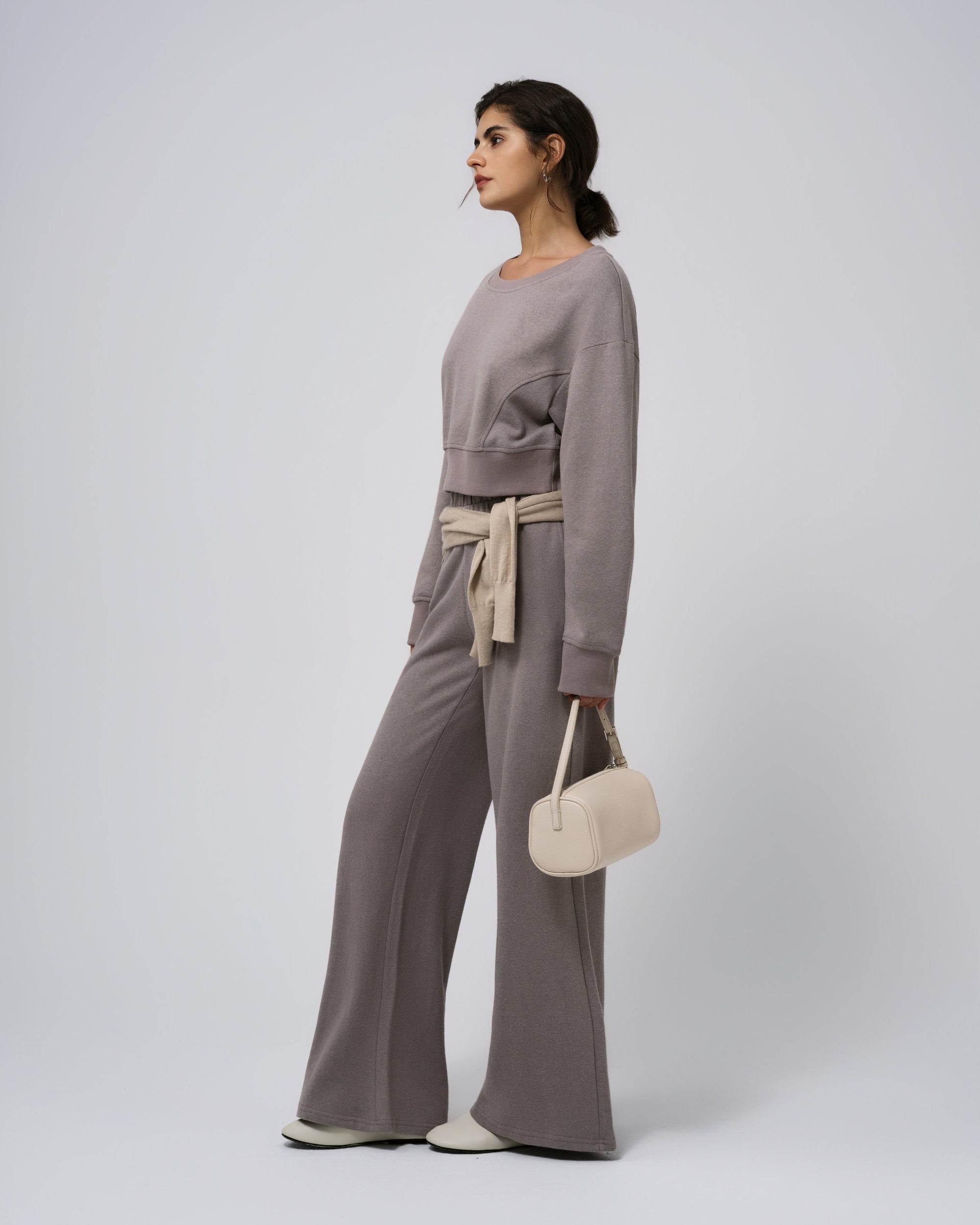 Side view of gray fleece sweatpants; mid‑rise waist and taper.