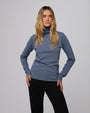 Woman wearing Juana Hemp Essentials Mockneck in blue hemp–organic cotton stretch blend, styled for sustainable everyday wear.