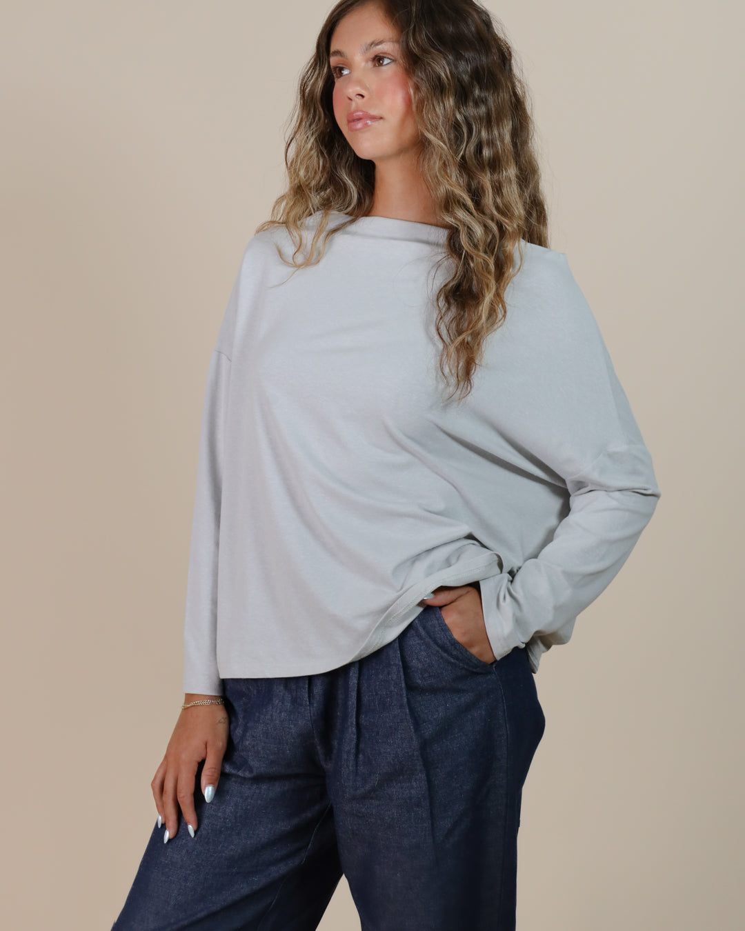Woman wearing Juana Hemp Essentials Off The Shoulder Top in ash, showcasing sustainable hemp blend long sleeve style.